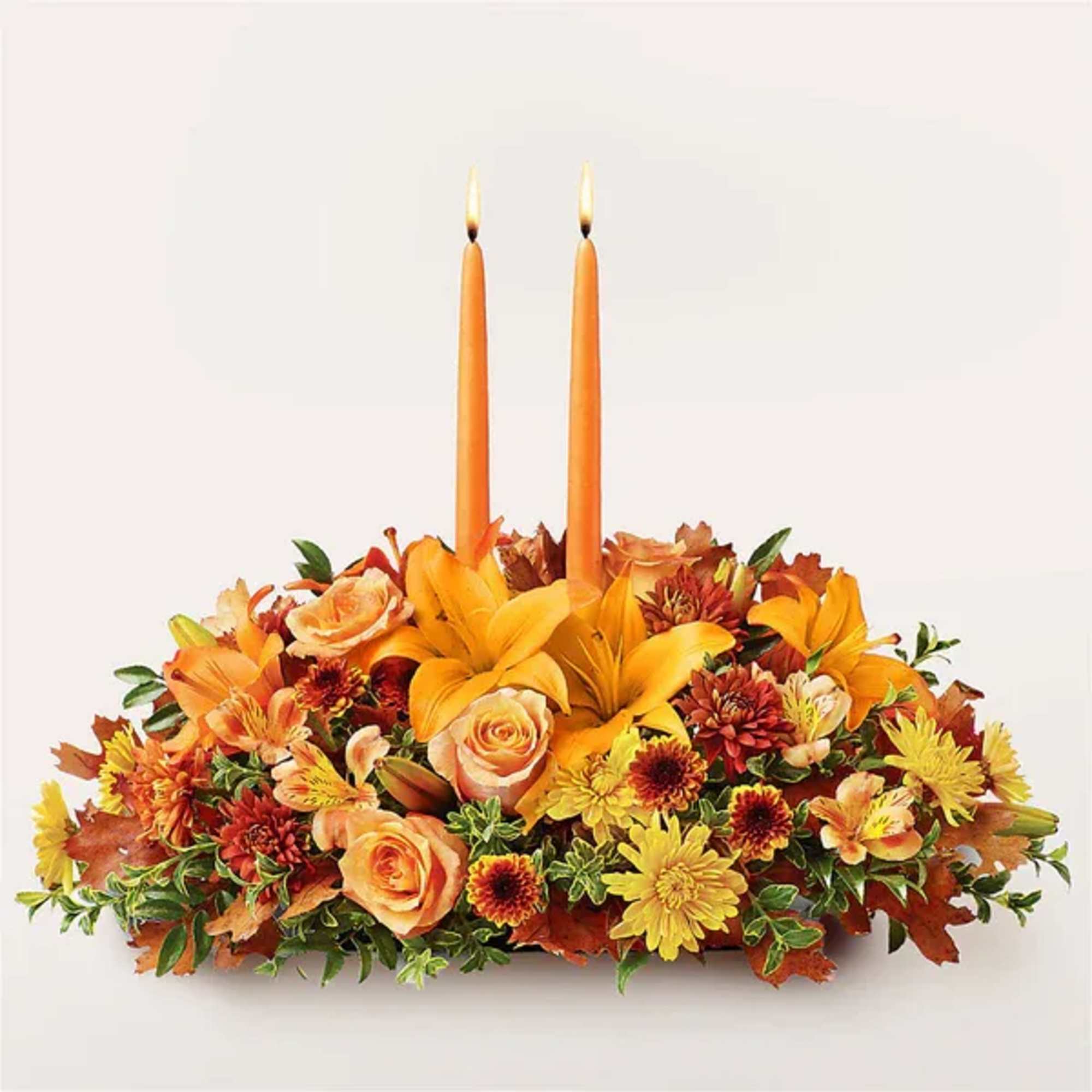 Autumn floral centerpiece with two orange taper candles