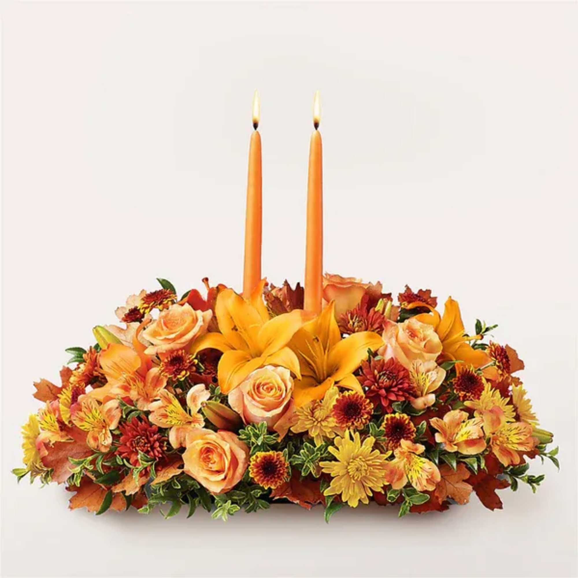 Autumn floral centerpiece with two orange candles