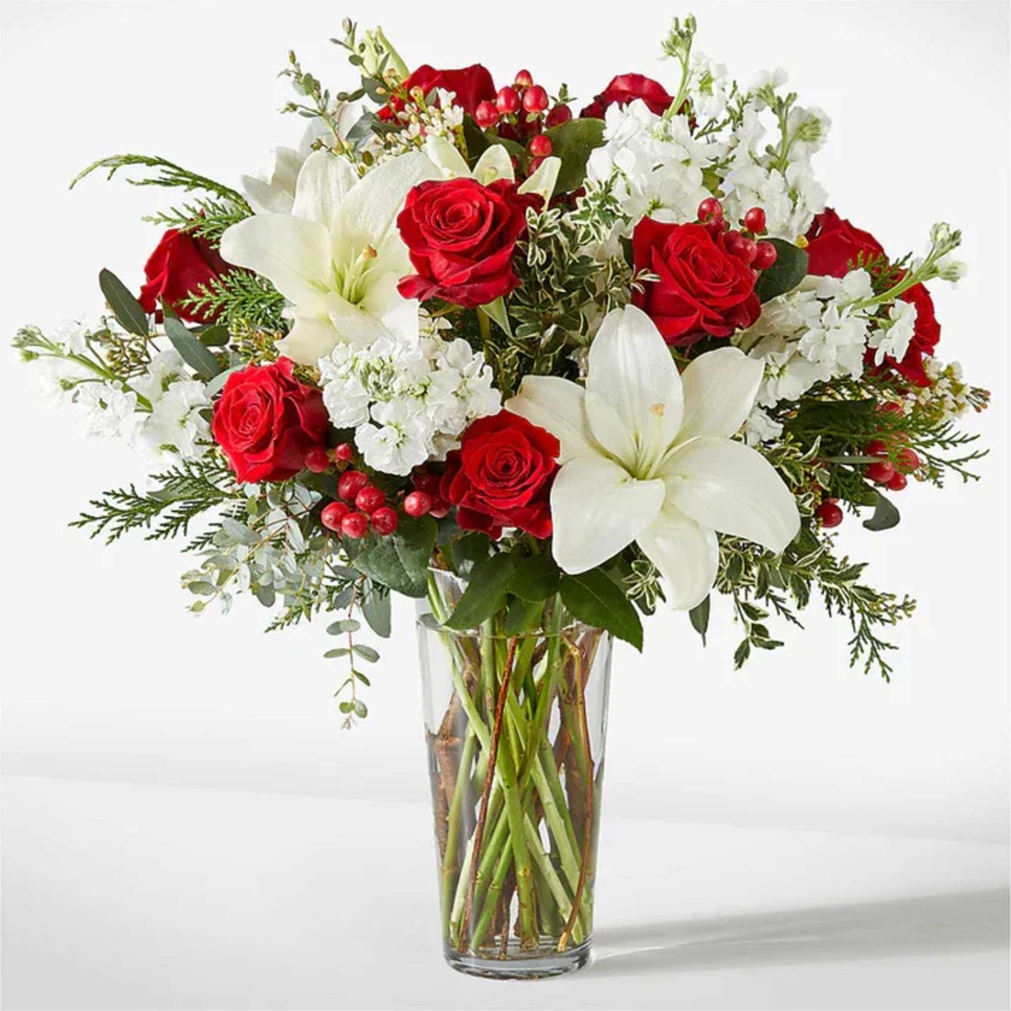 Red roses and white lilies arranged in a clear glass vase