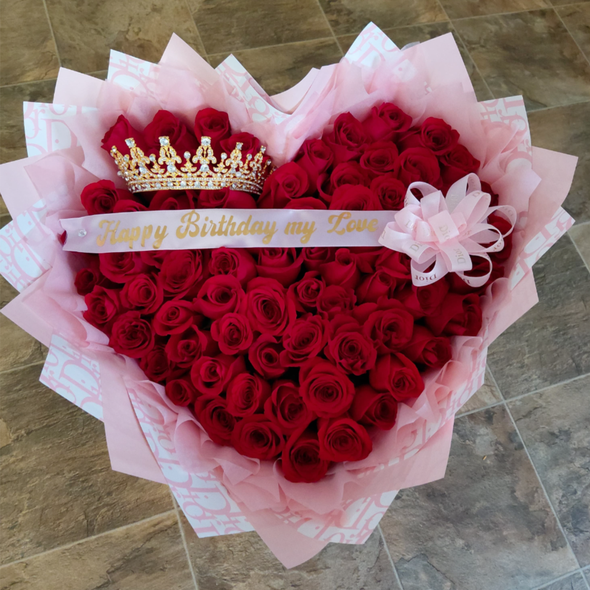 Heart-shaped bouquet of red roses with a crown and birthday ribbon
