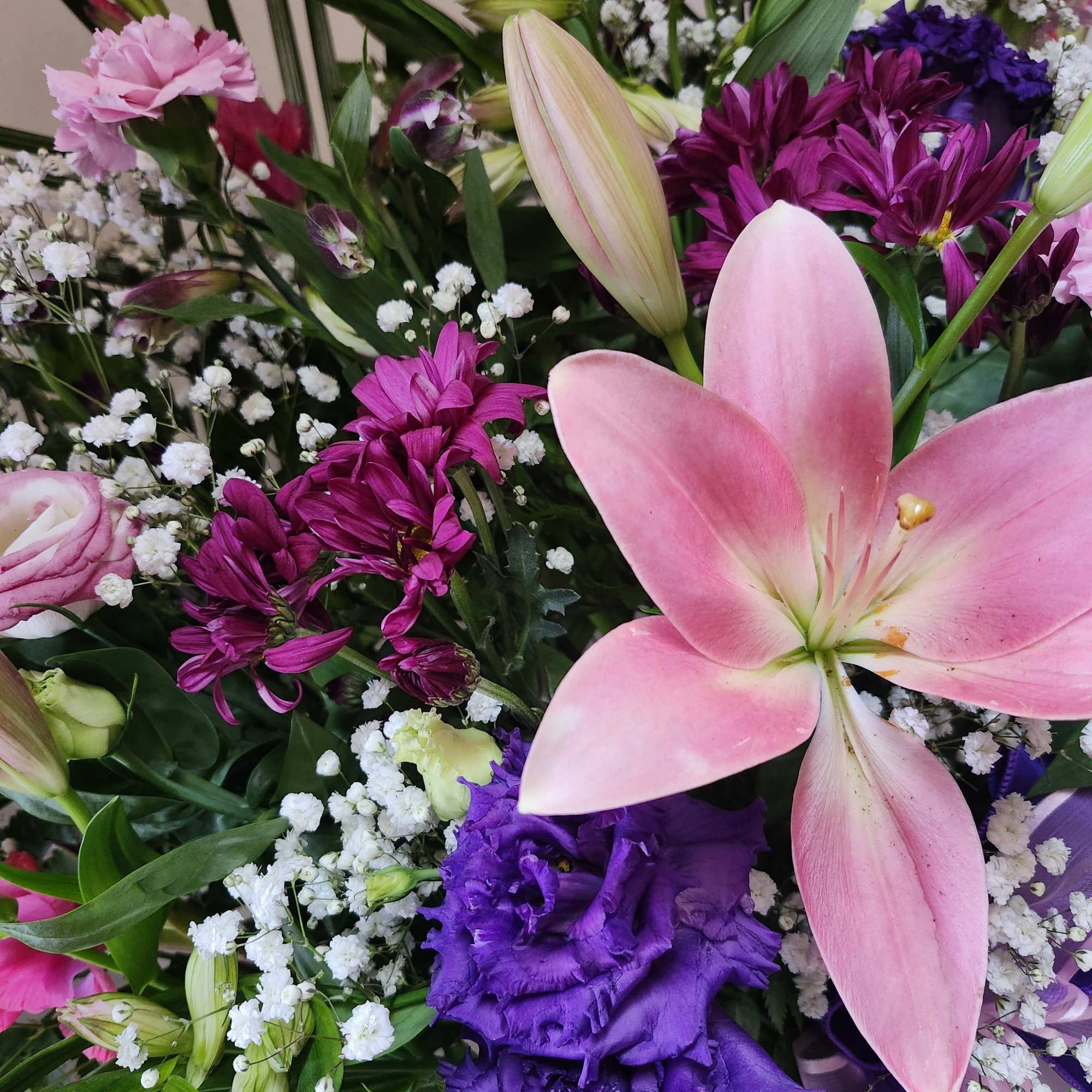 Bouquet of pink lilies, purple blooms, and white baby's breath