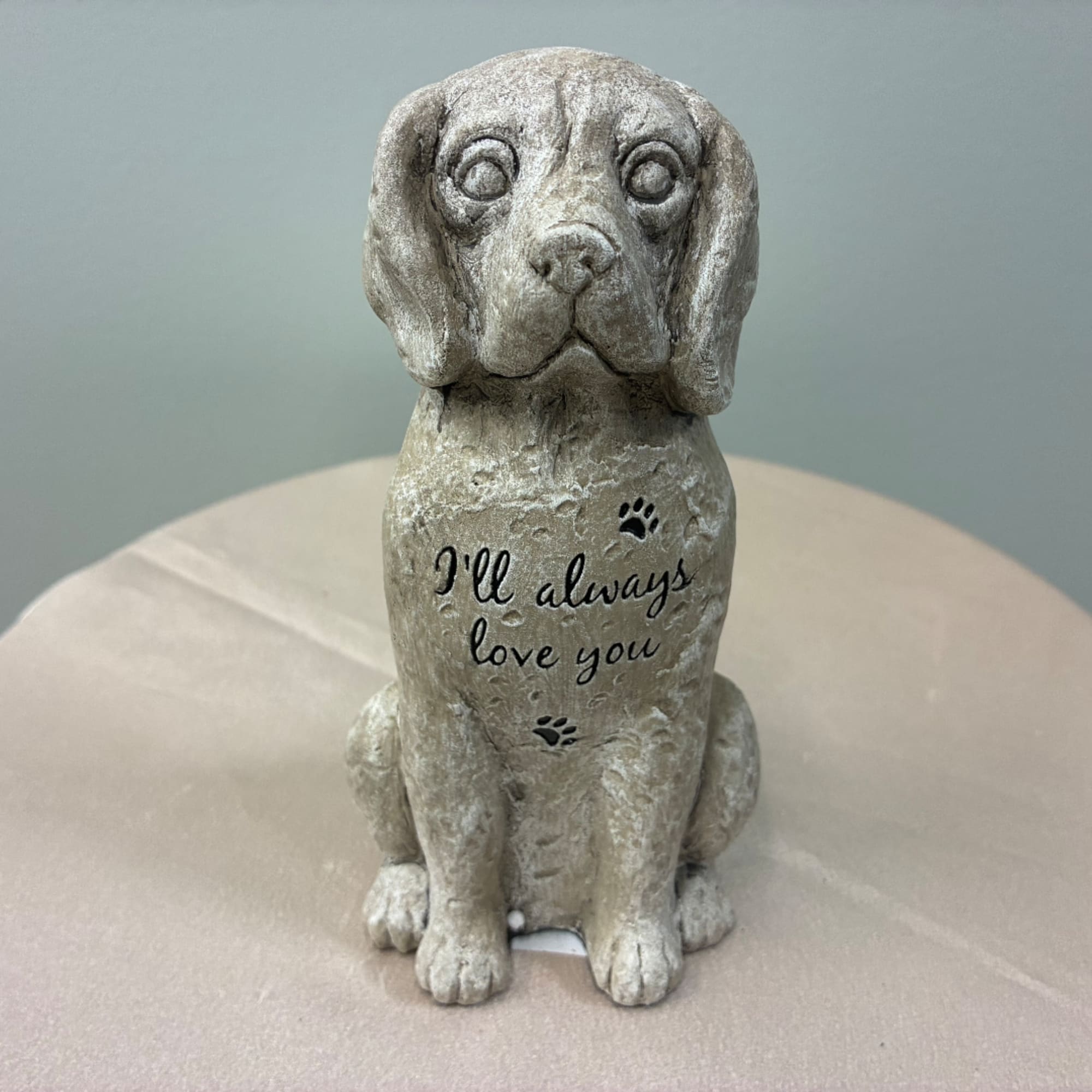 Stone dog figurine with the words "I'll always love you" on its chest