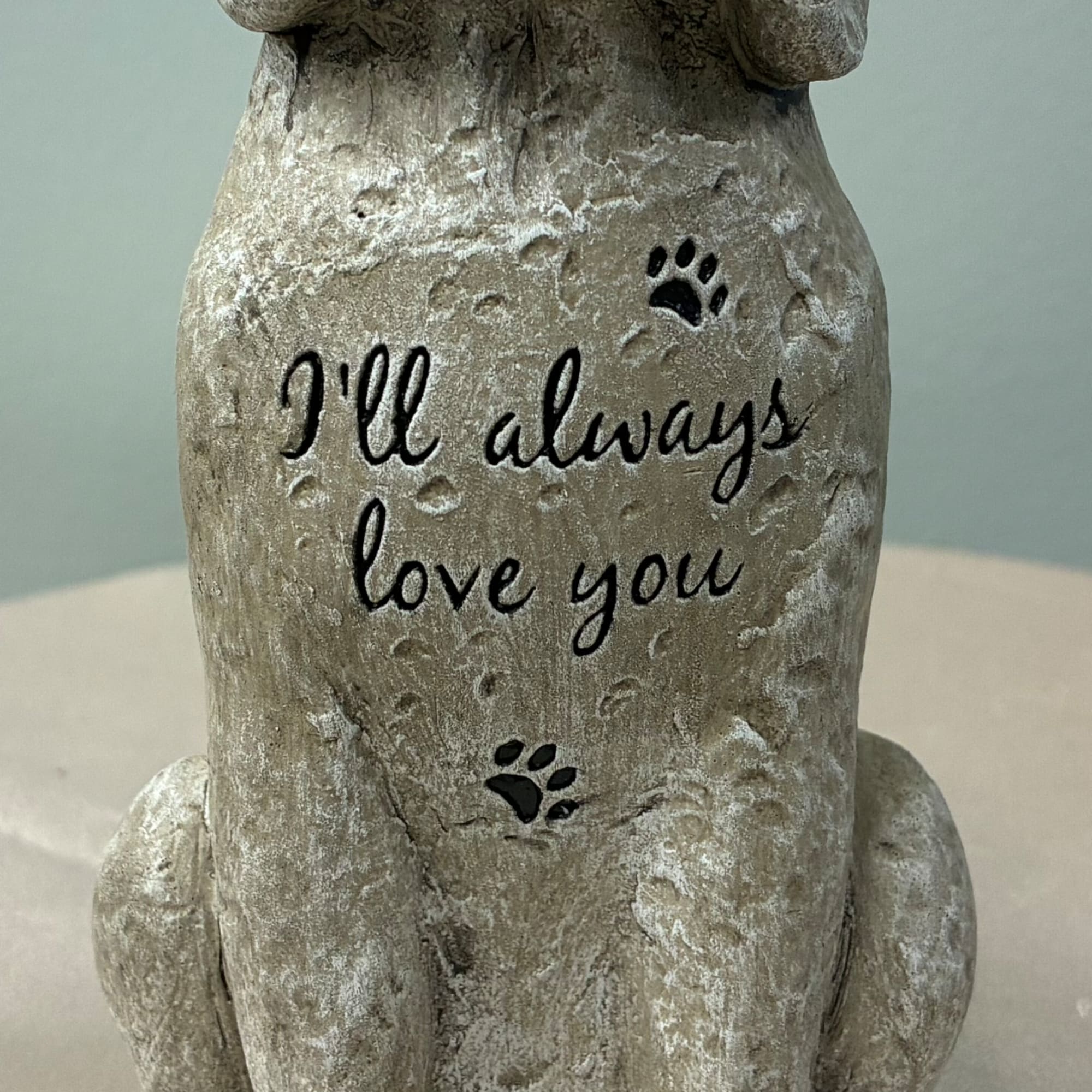 Stone dog figurine with the words "I'll always love you" on its front