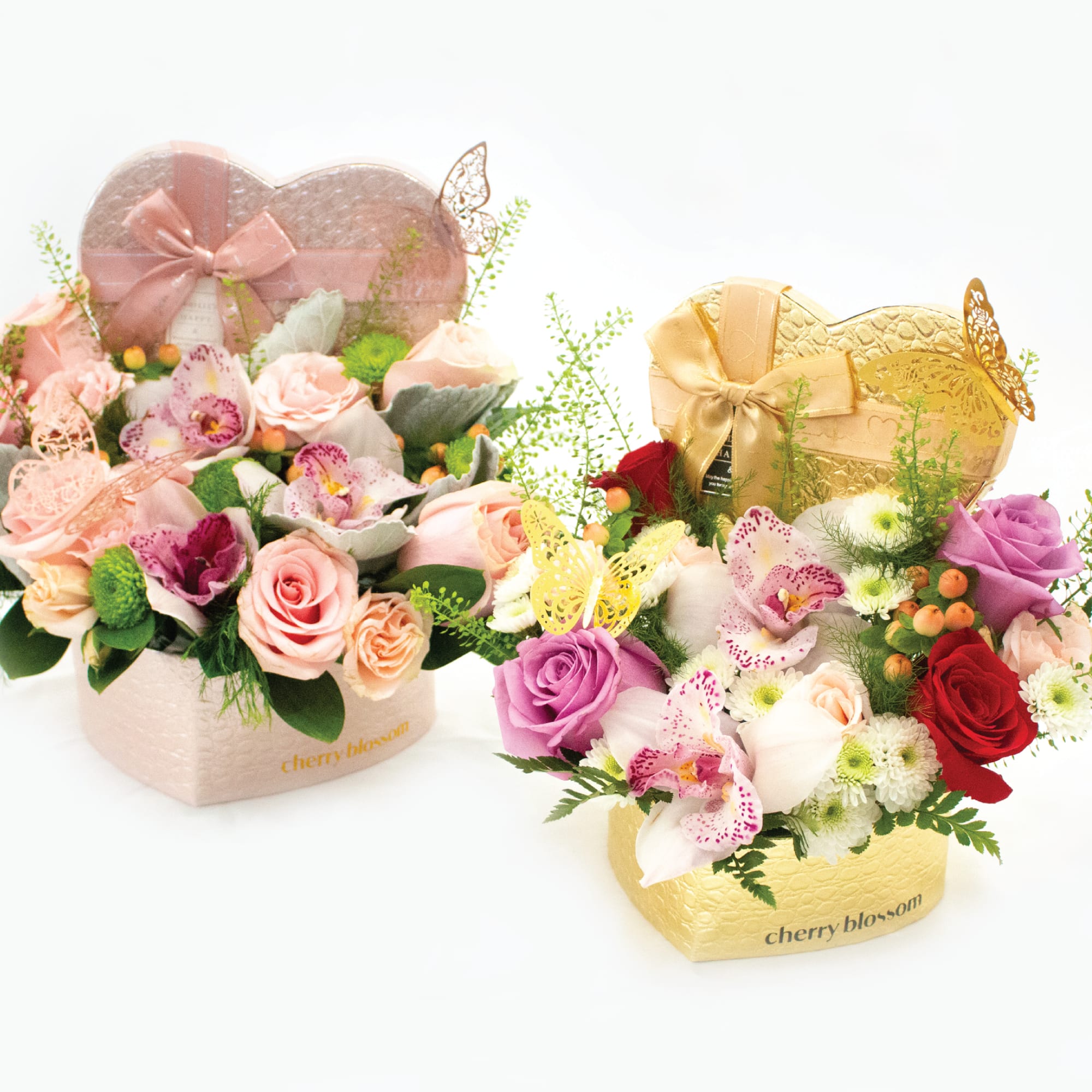 Two heart-shaped floral gift boxes with roses and orchids