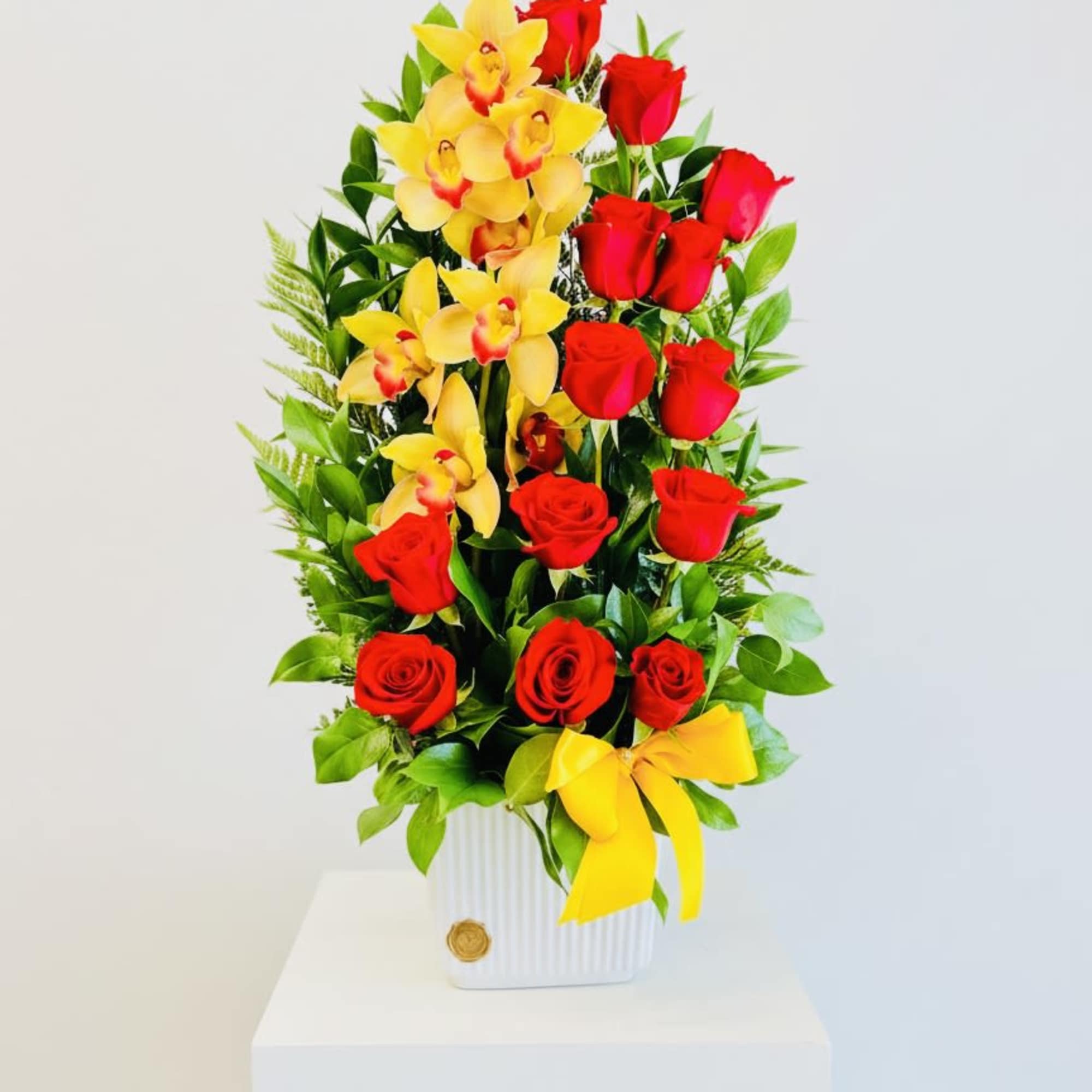 Large Arrangement with orchids and roses on a ceramic vase.