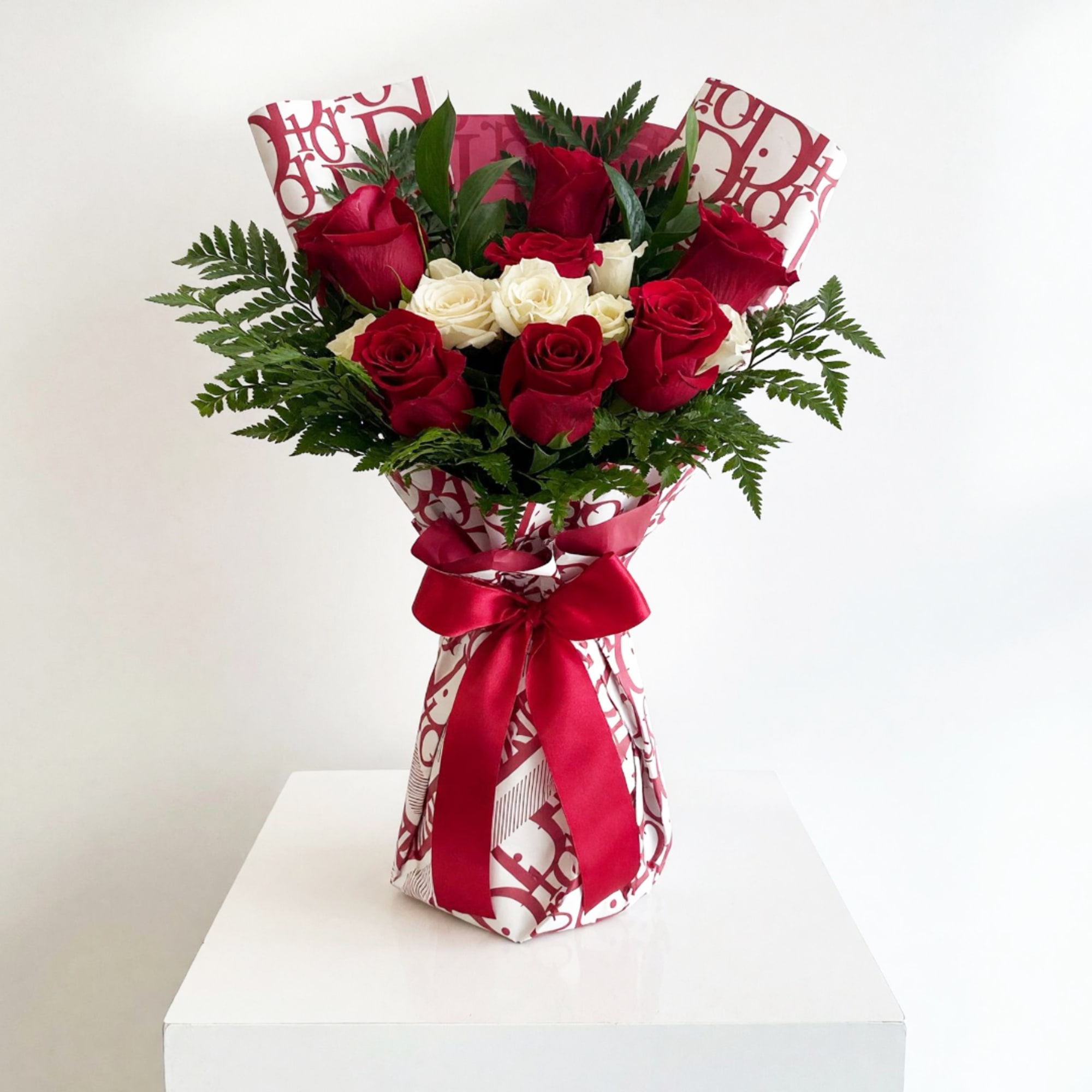 Bouquet of red and white roses wrapped in patterned paper with a red ribbon, photo 2 of 2