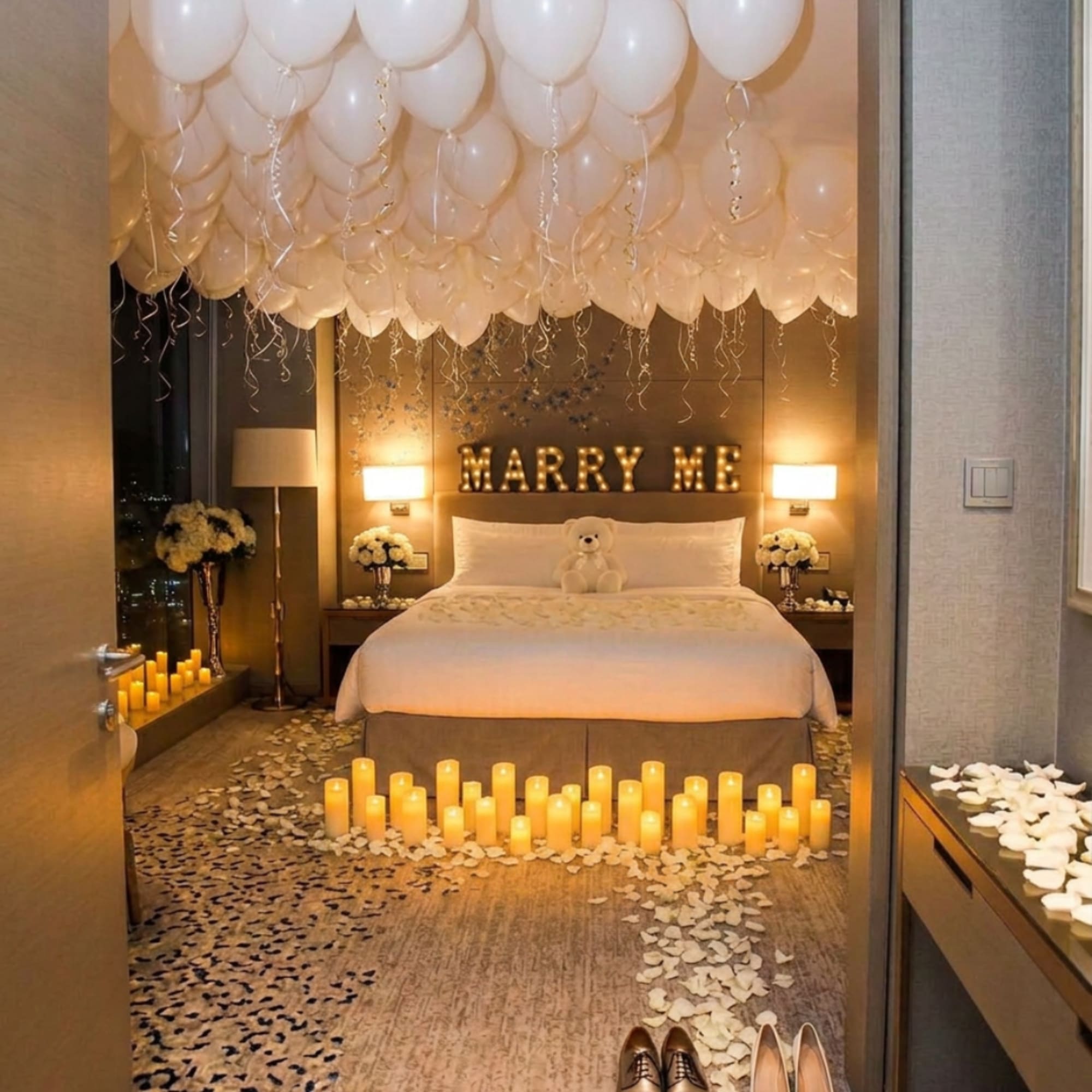 Romantic bedroom setup with balloons, candles, rose petals, and a teddy bear