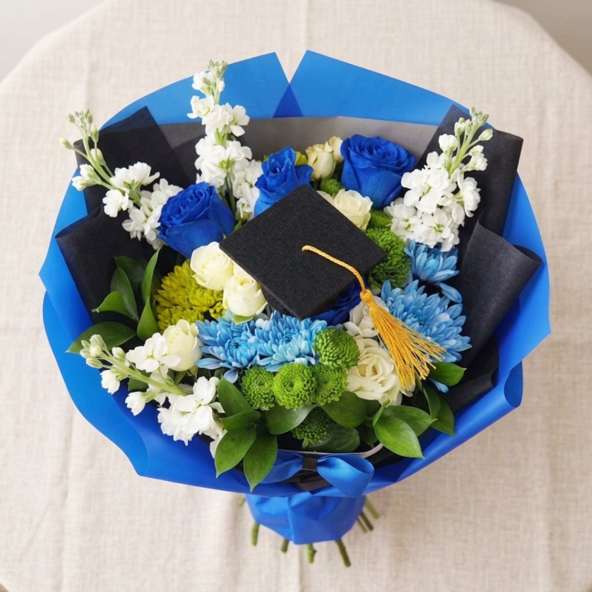 Blue and white bouquet with a graduation cap topper