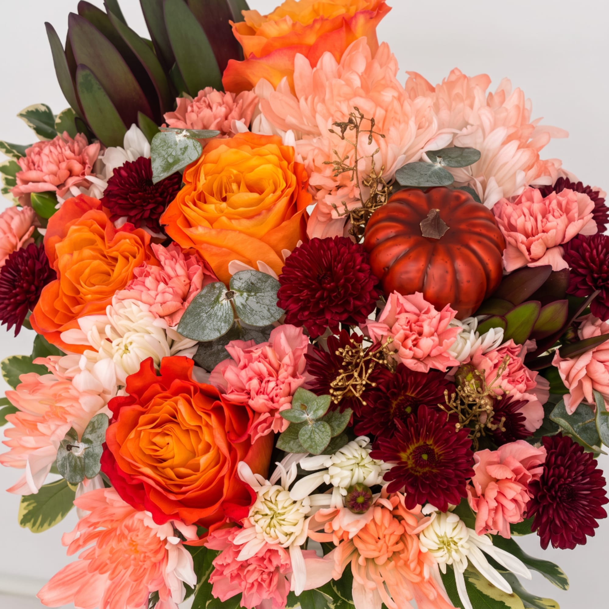 Bouquet of orange roses, pink chrysanthemums, and burgundy blooms