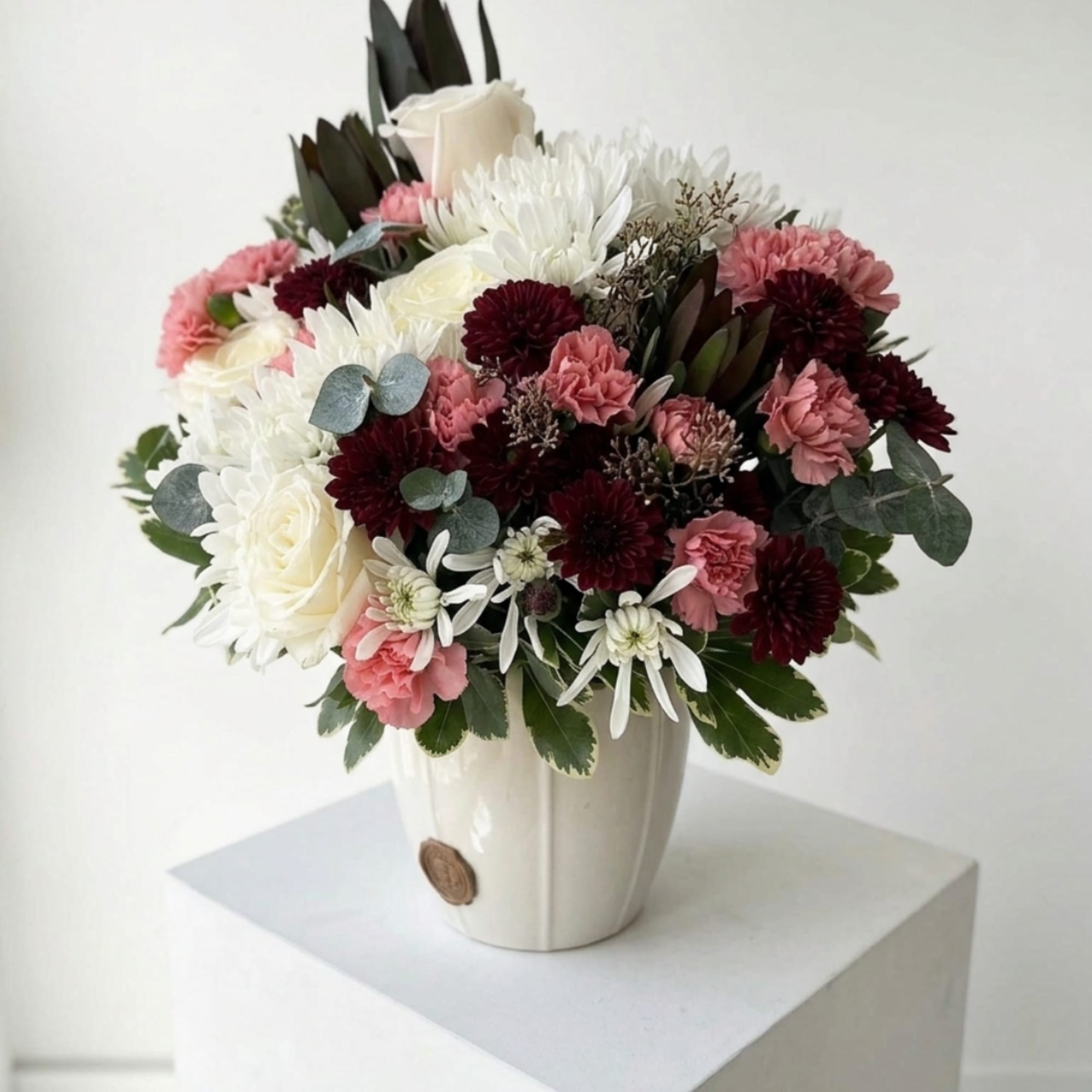 Mixed bouquet of white, pink, and burgundy flowers in a white vase, photo 2 of 4