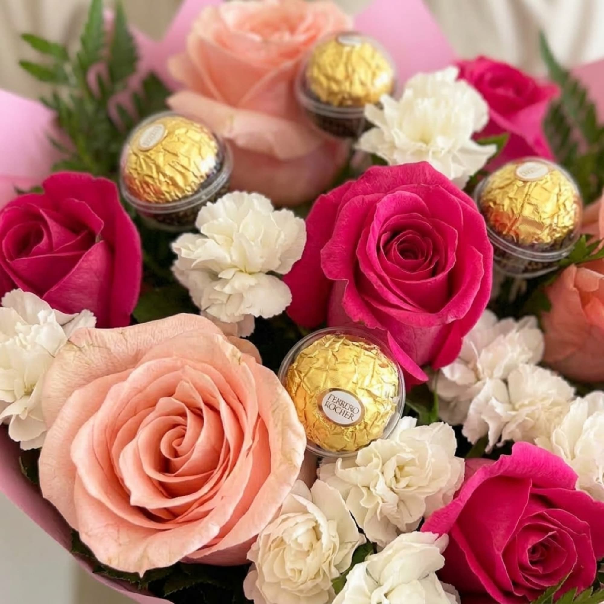 Pink and peach roses with white carnations and Ferrero Rocher chocolates