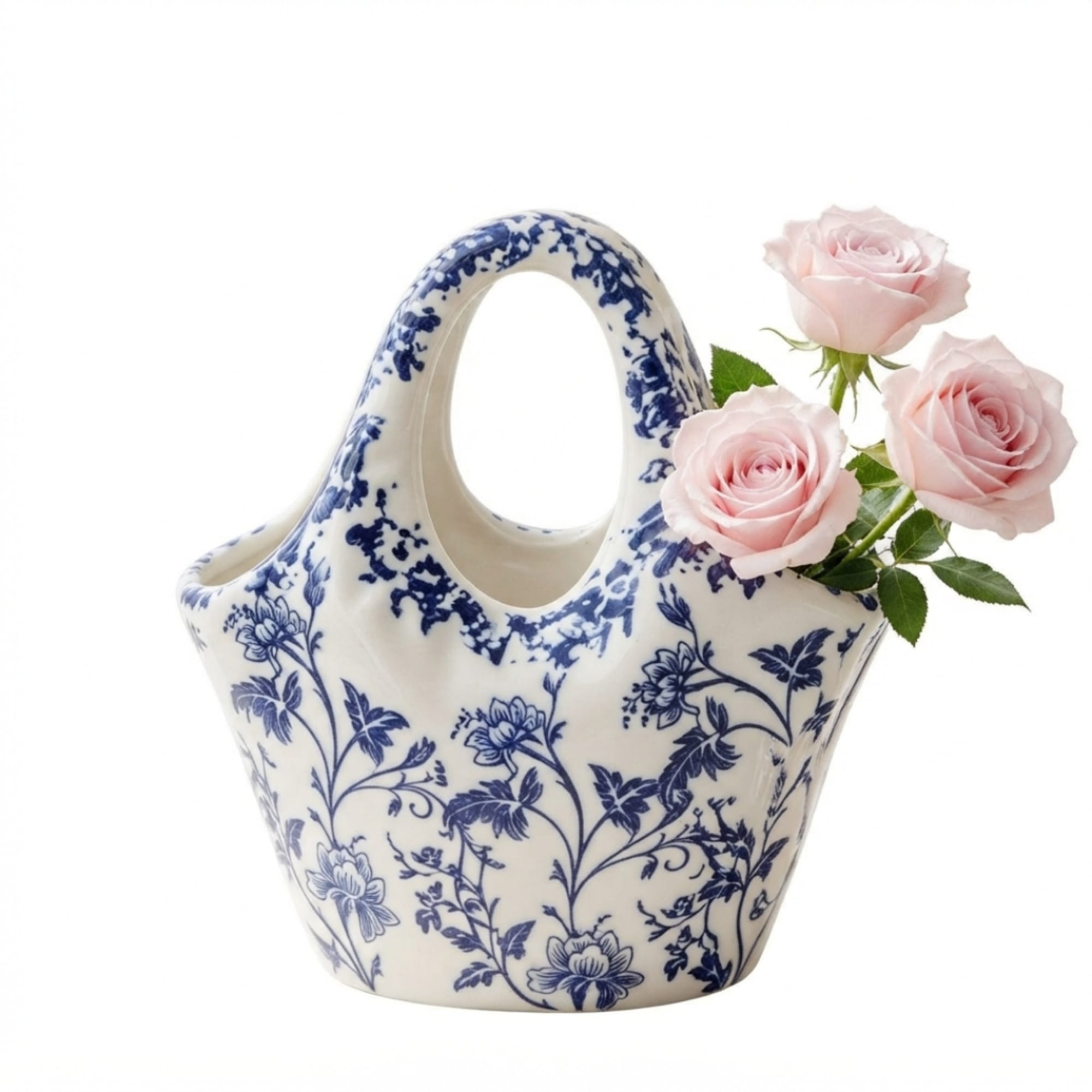 Three pale pink roses in a blue-and-white ceramic basket vase