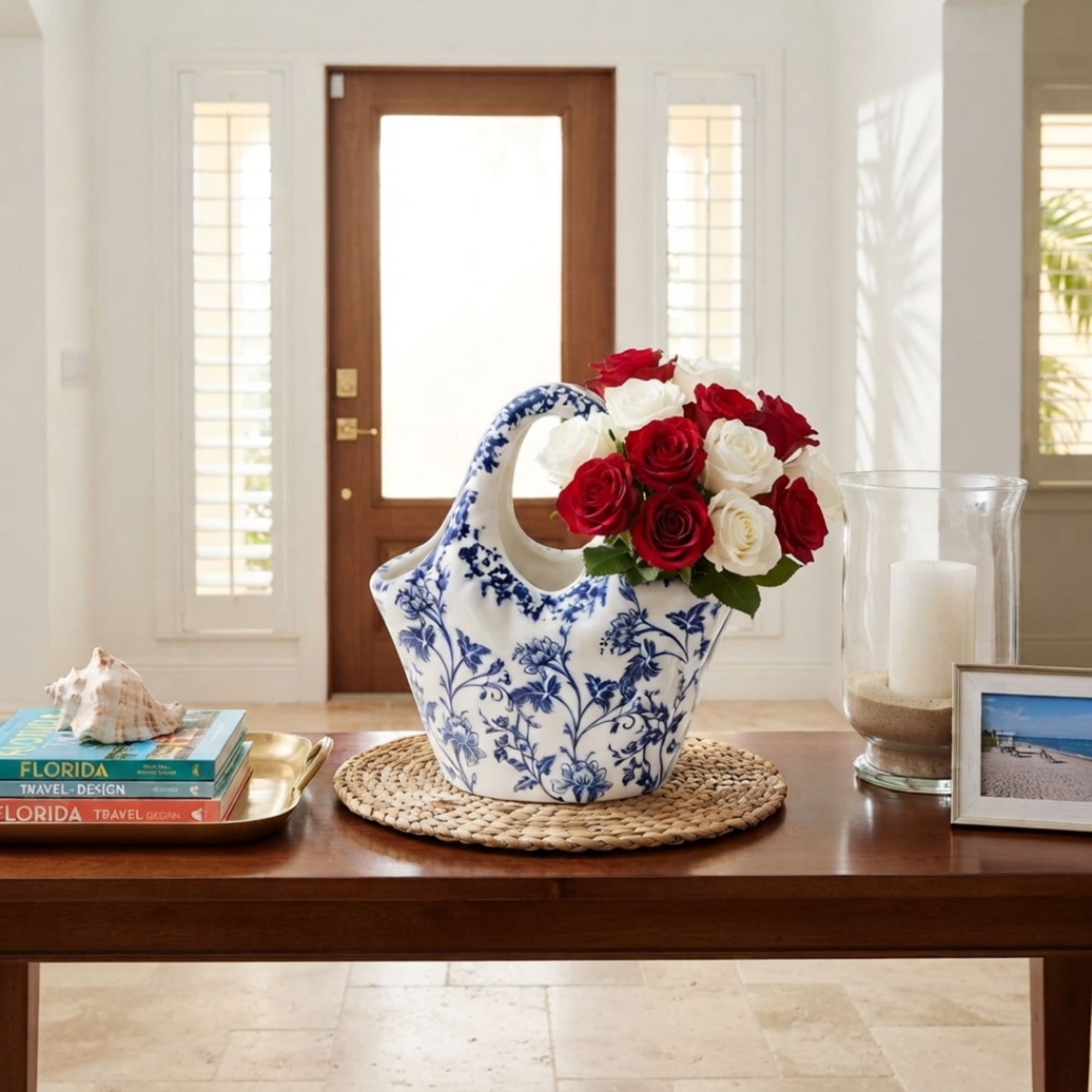 Red and white roses in a blue-and-white ceramic vase on a table