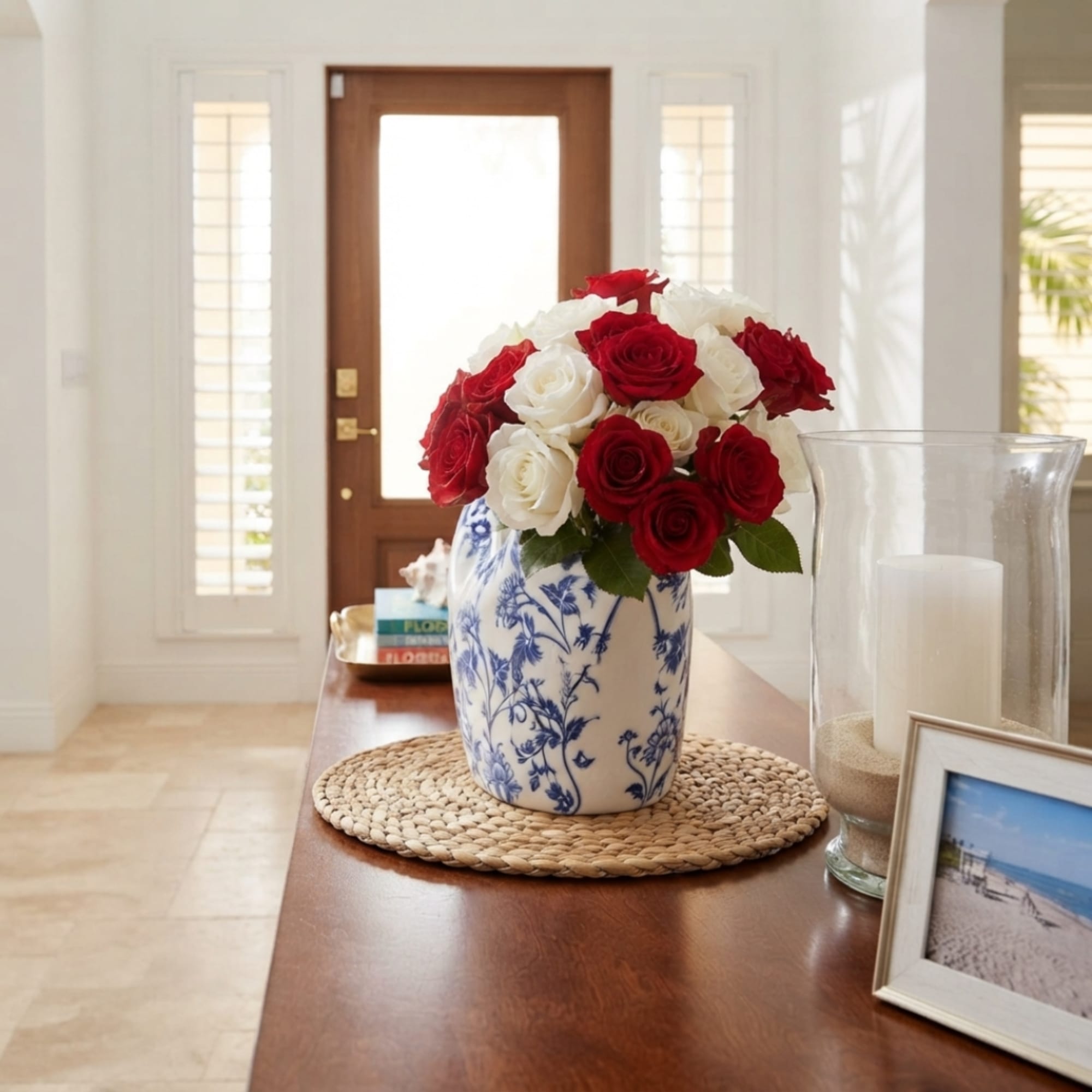 Red and white roses arranged in a blue-and-white ceramic vase