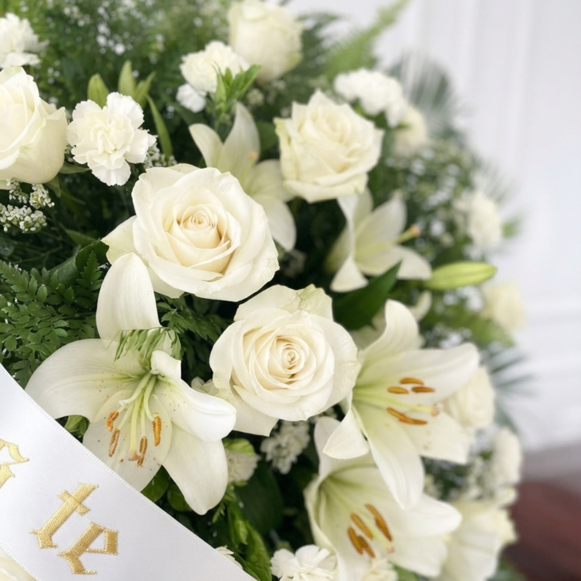 White roses and lilies arranged with small white filler flowers