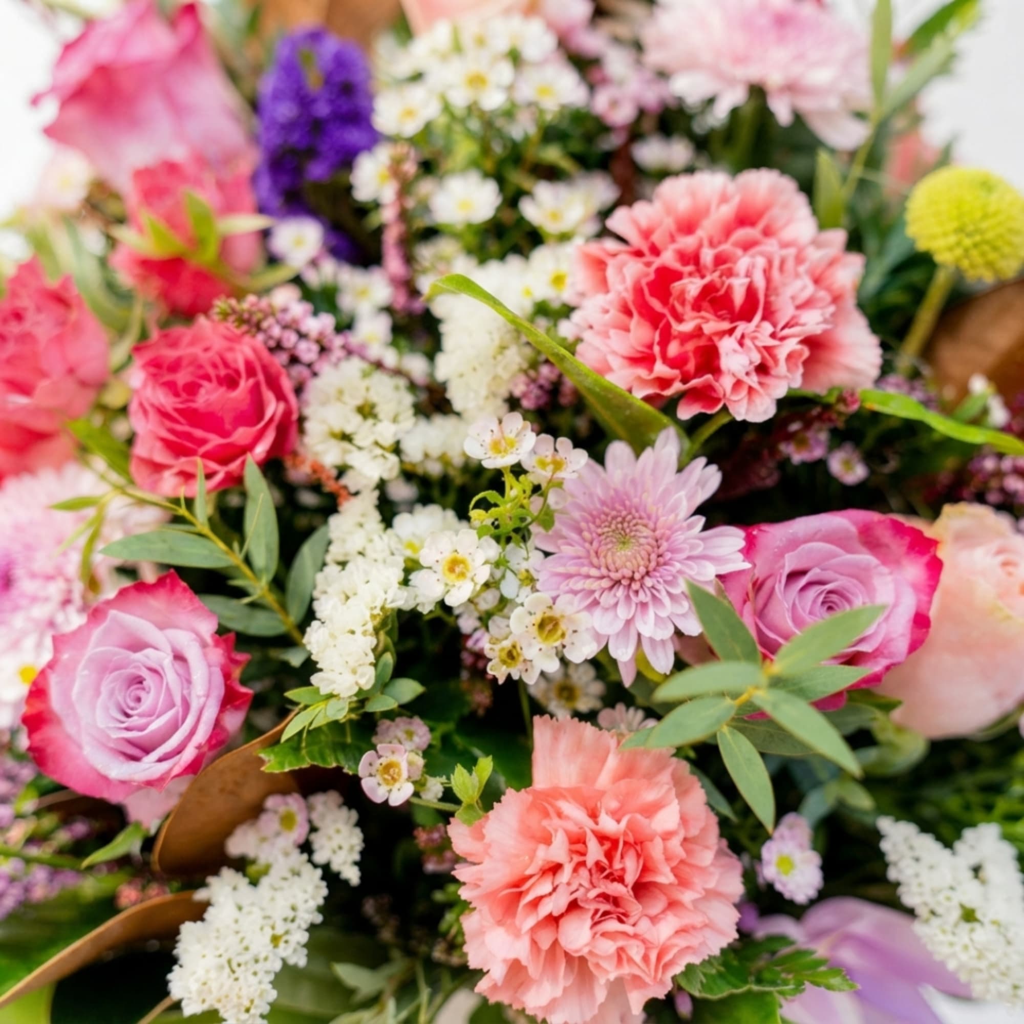 Mixed bouquet of pink roses, carnations, and small white flowers
