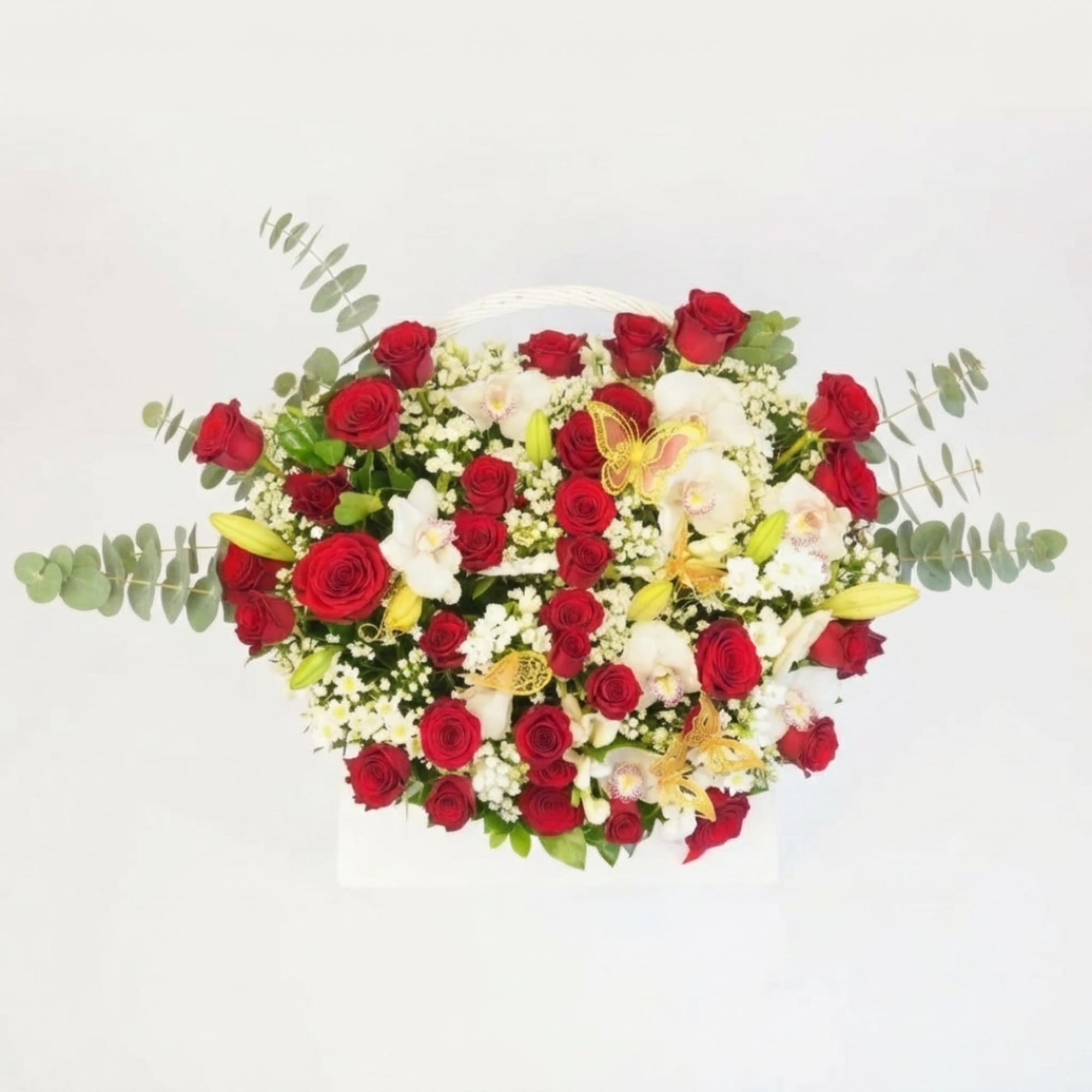 Heart-shaped arrangement of red roses and white orchids with eucalyptus