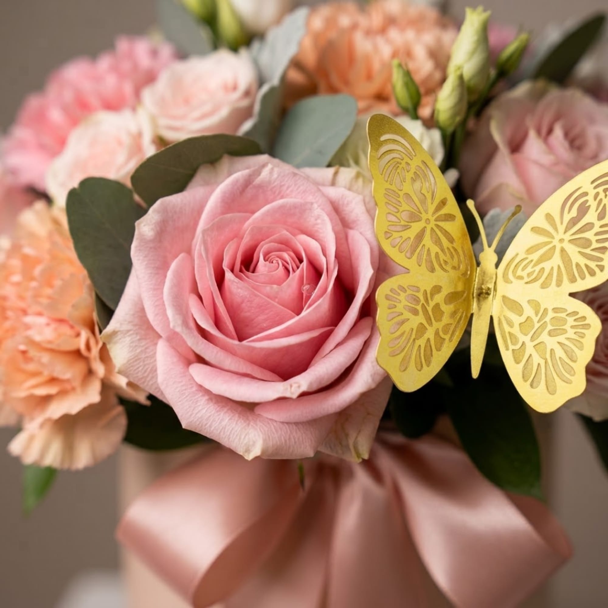 Pink and peach rose bouquet with a gold butterfly pick and satin ribbon