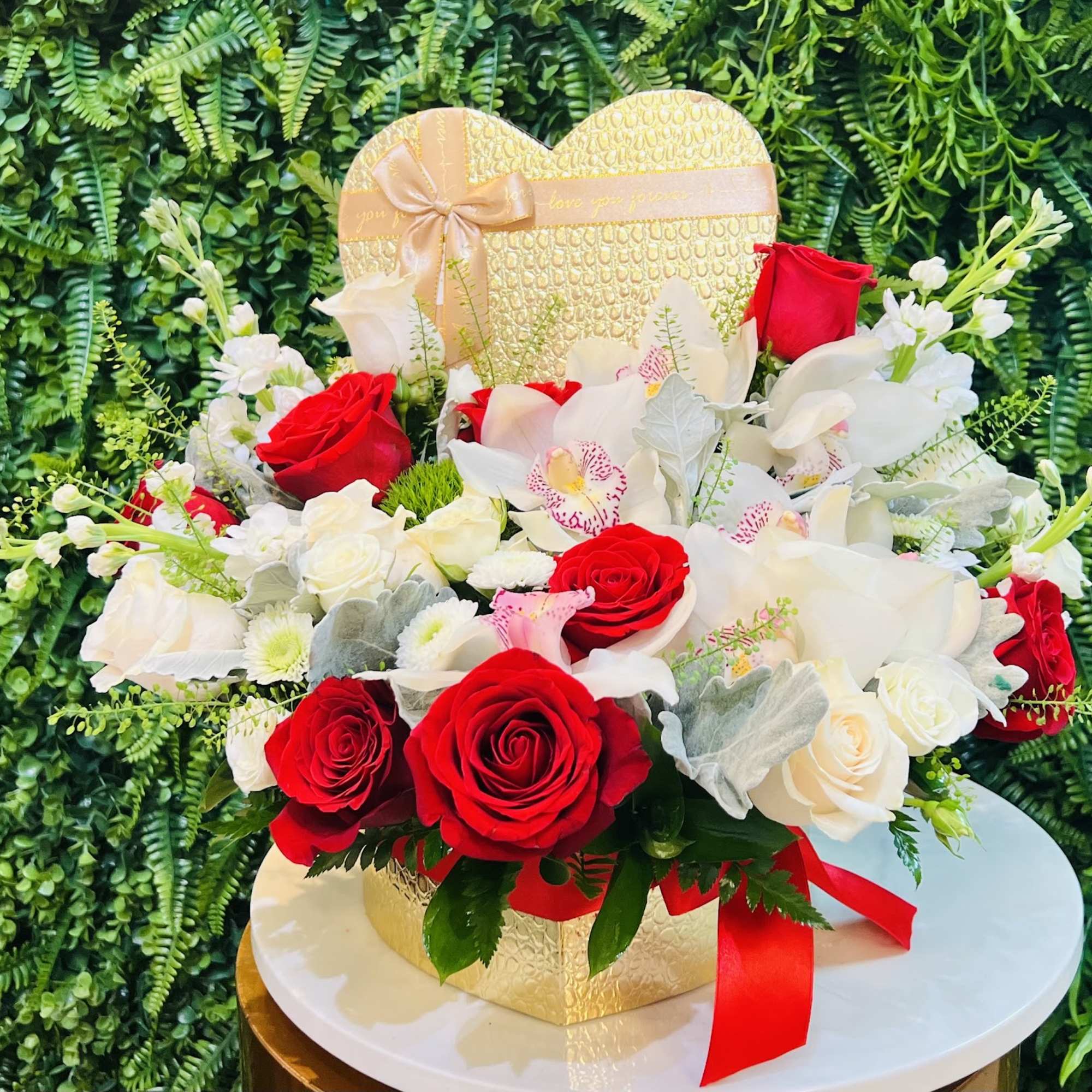 Heart-shaped gift box with red and white roses and orchids