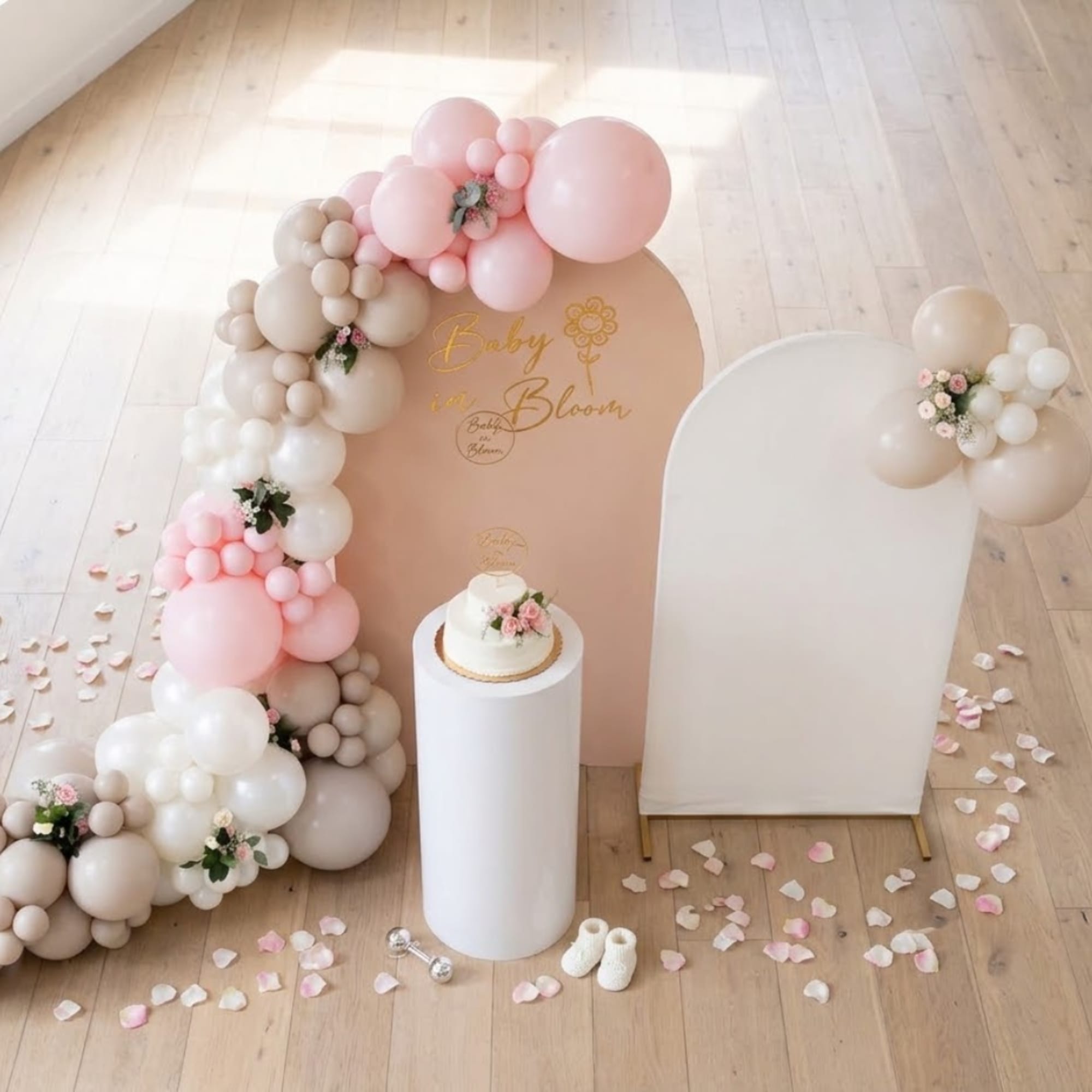 Pastel balloon arch with small floral accents around a baby shower backdrop, photo 8 of 8