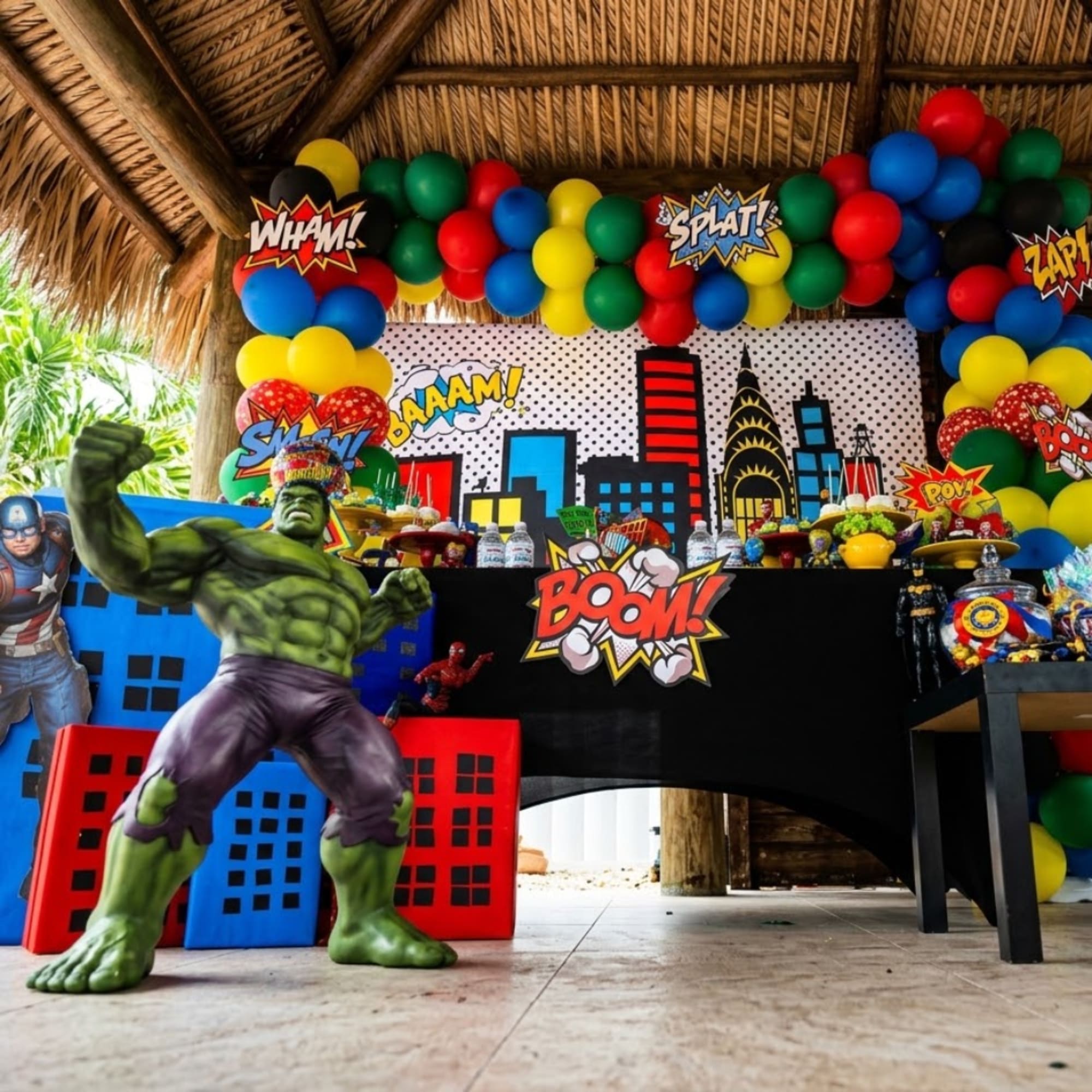 Superhero-themed party display with balloons, comic signs, and character cutouts