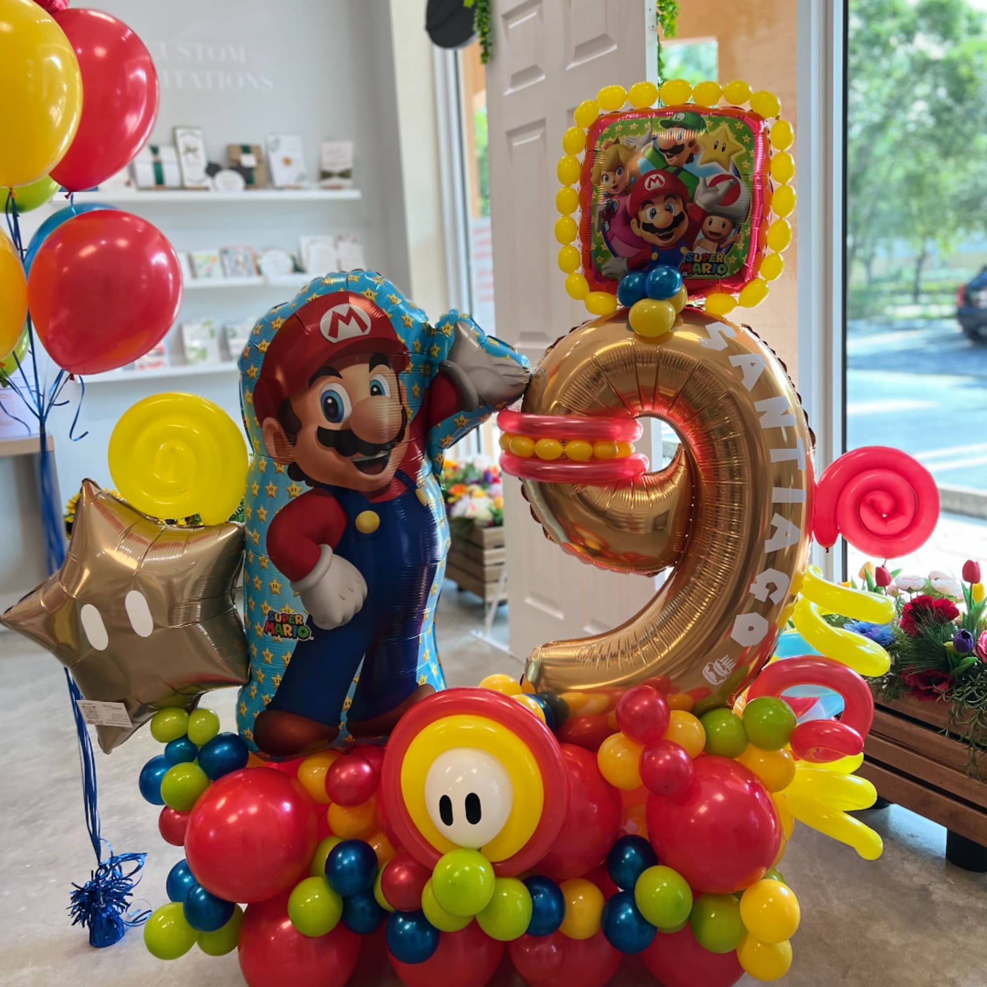 Mario-themed balloon display with a large gold number 9 and colorful balloons