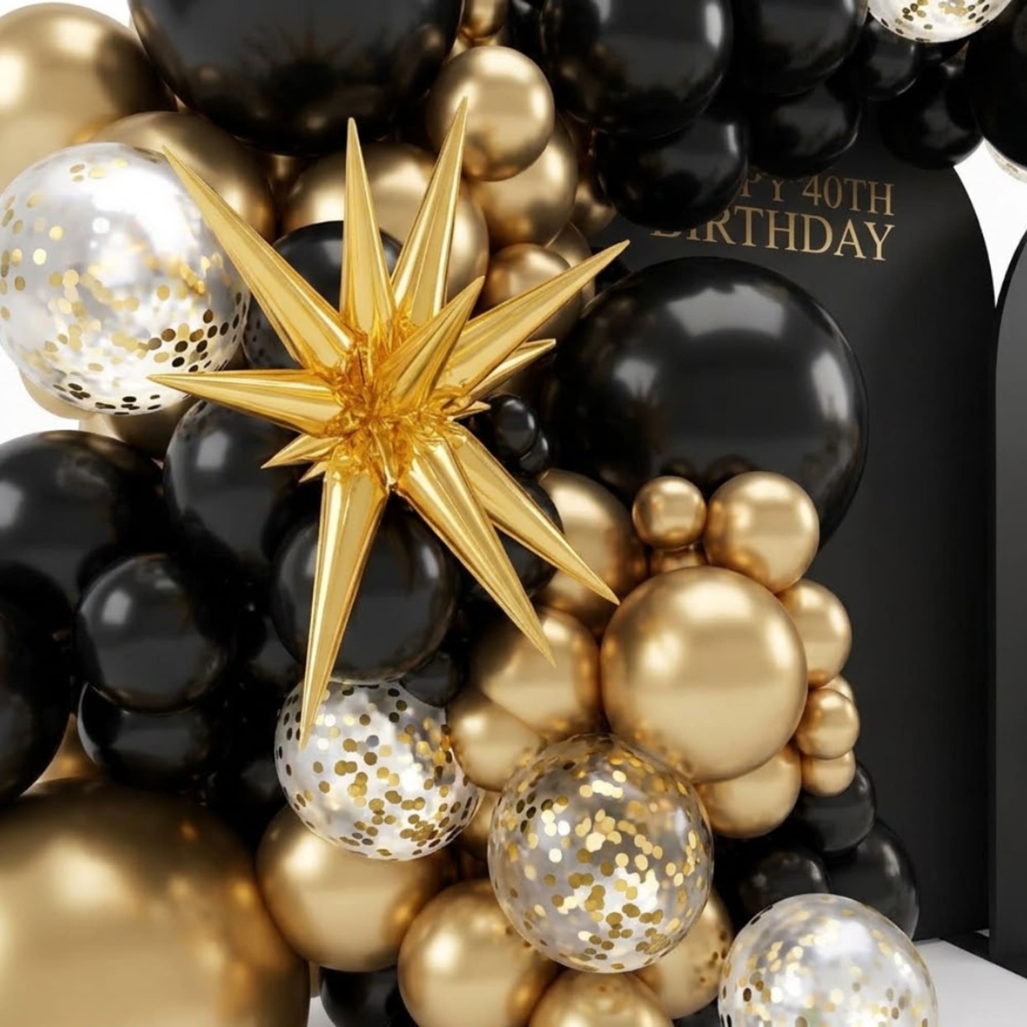 Black and gold birthday balloon display with a gold starburst centerpiece