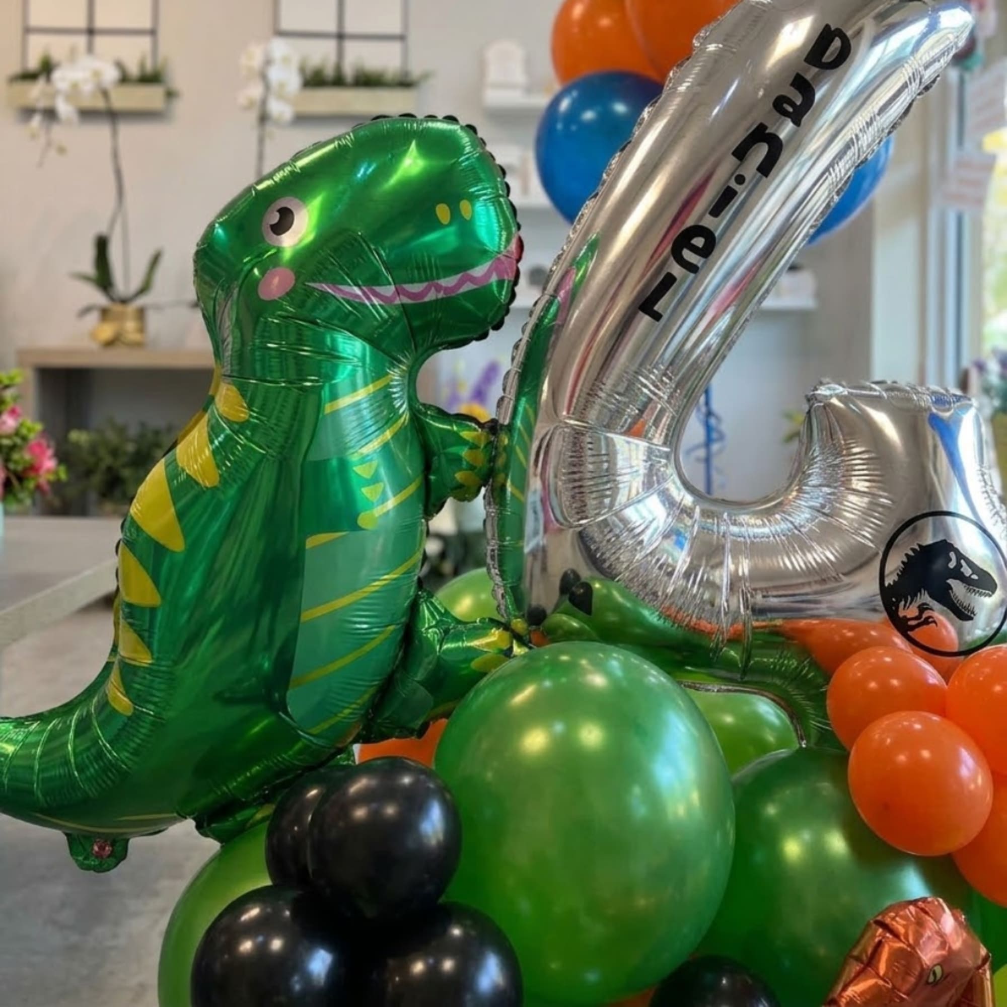 Dinosaur-shaped foil balloon surrounded by colorful balloons