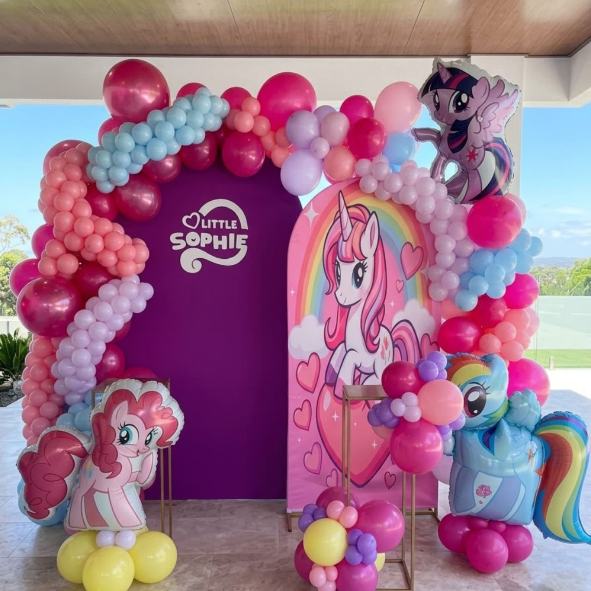 My Little Pony-themed balloon display with character cutouts and a purple backdrop