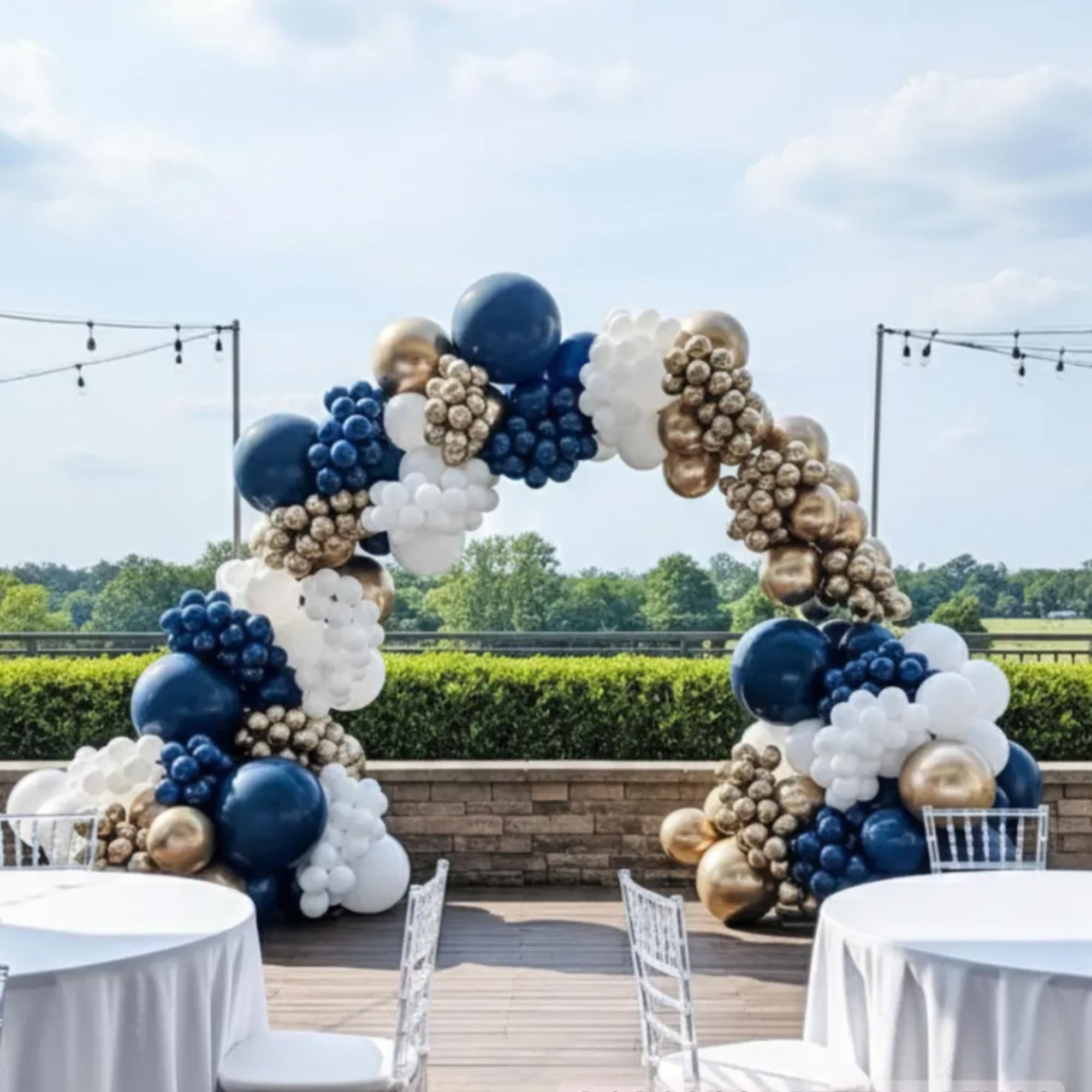 Blue, white, and gold balloon arch at an outdoor event
