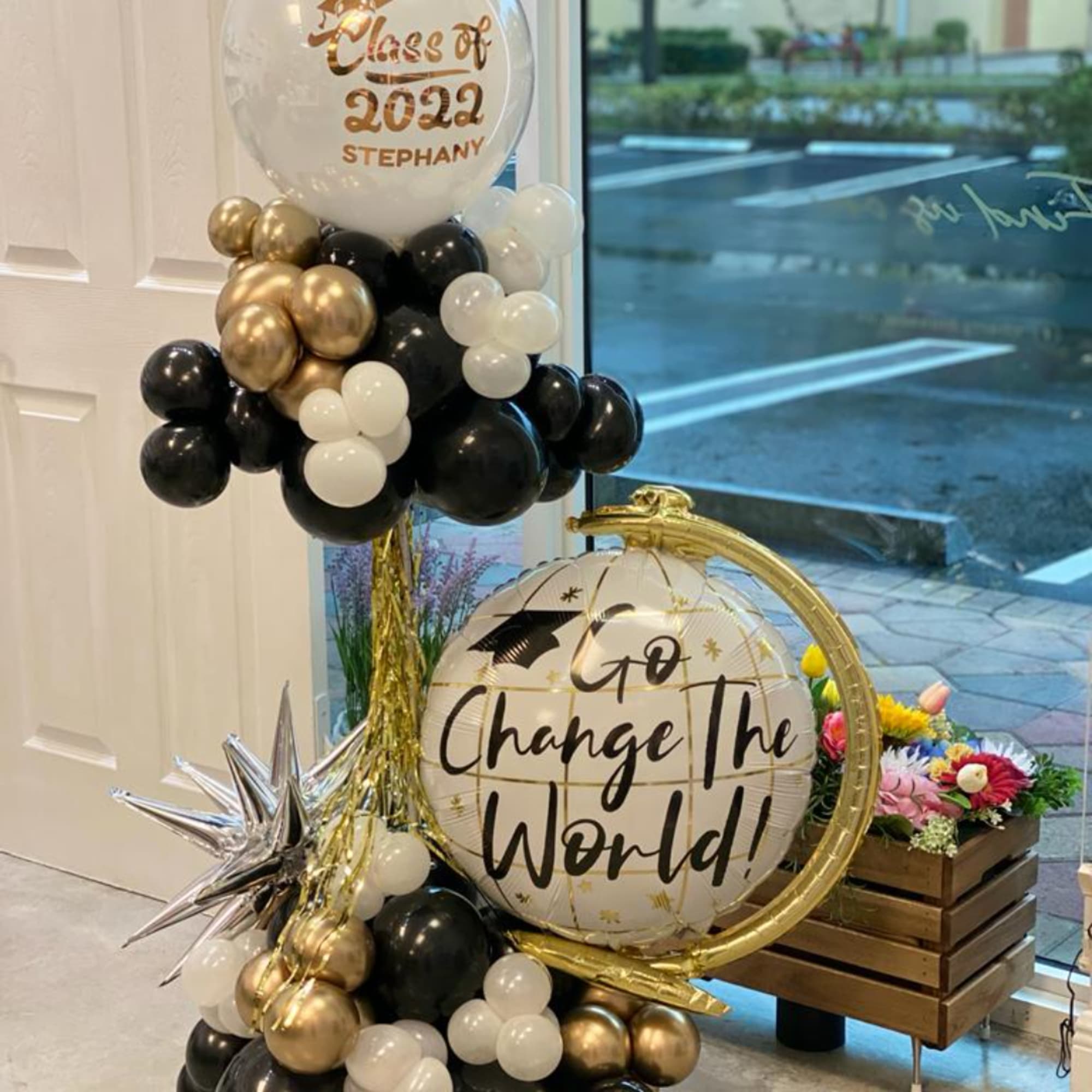 Balloon display with a graduation balloon and black, gold, and white balloons