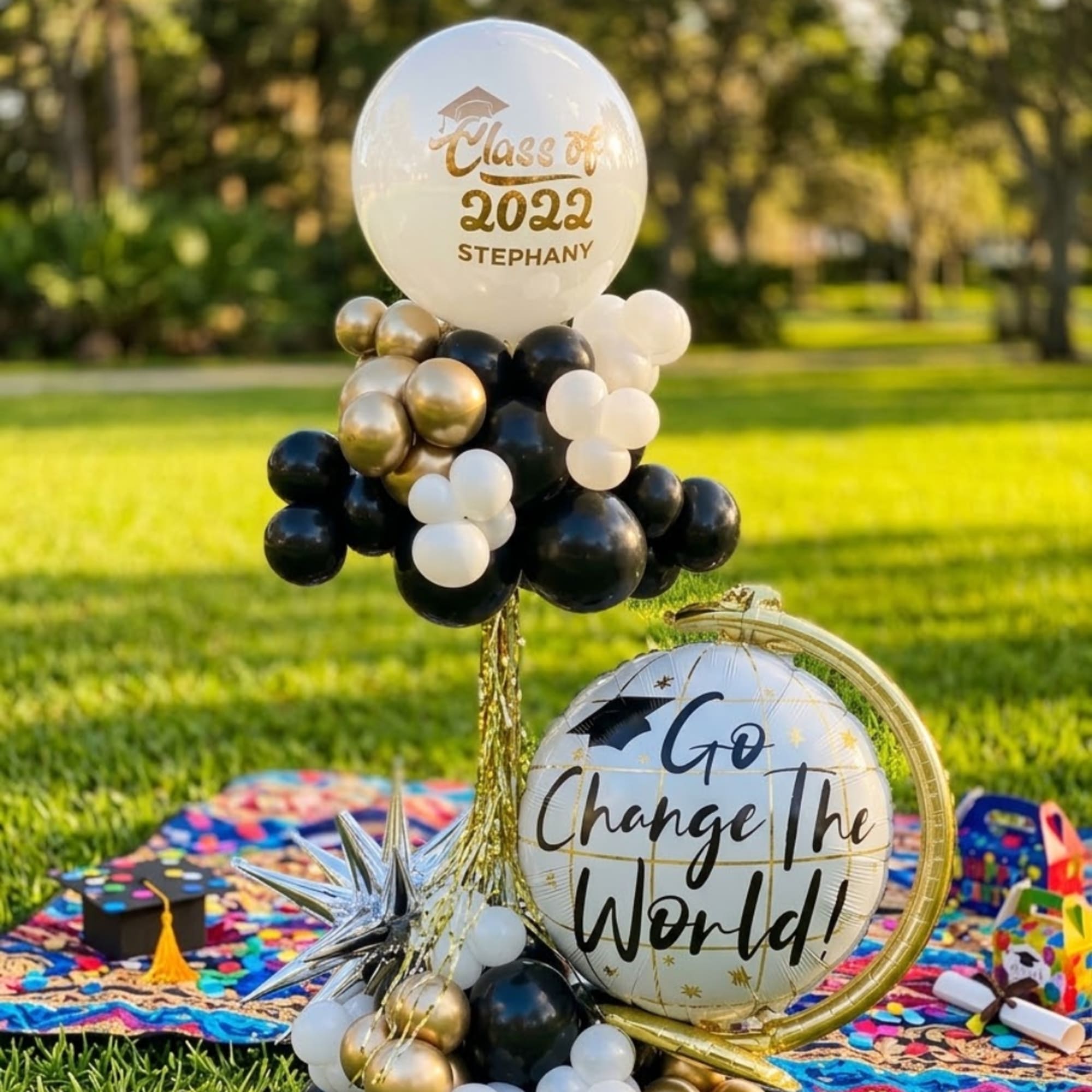 Graduation balloon display with black, white, and gold balloons and a large printed balloon.