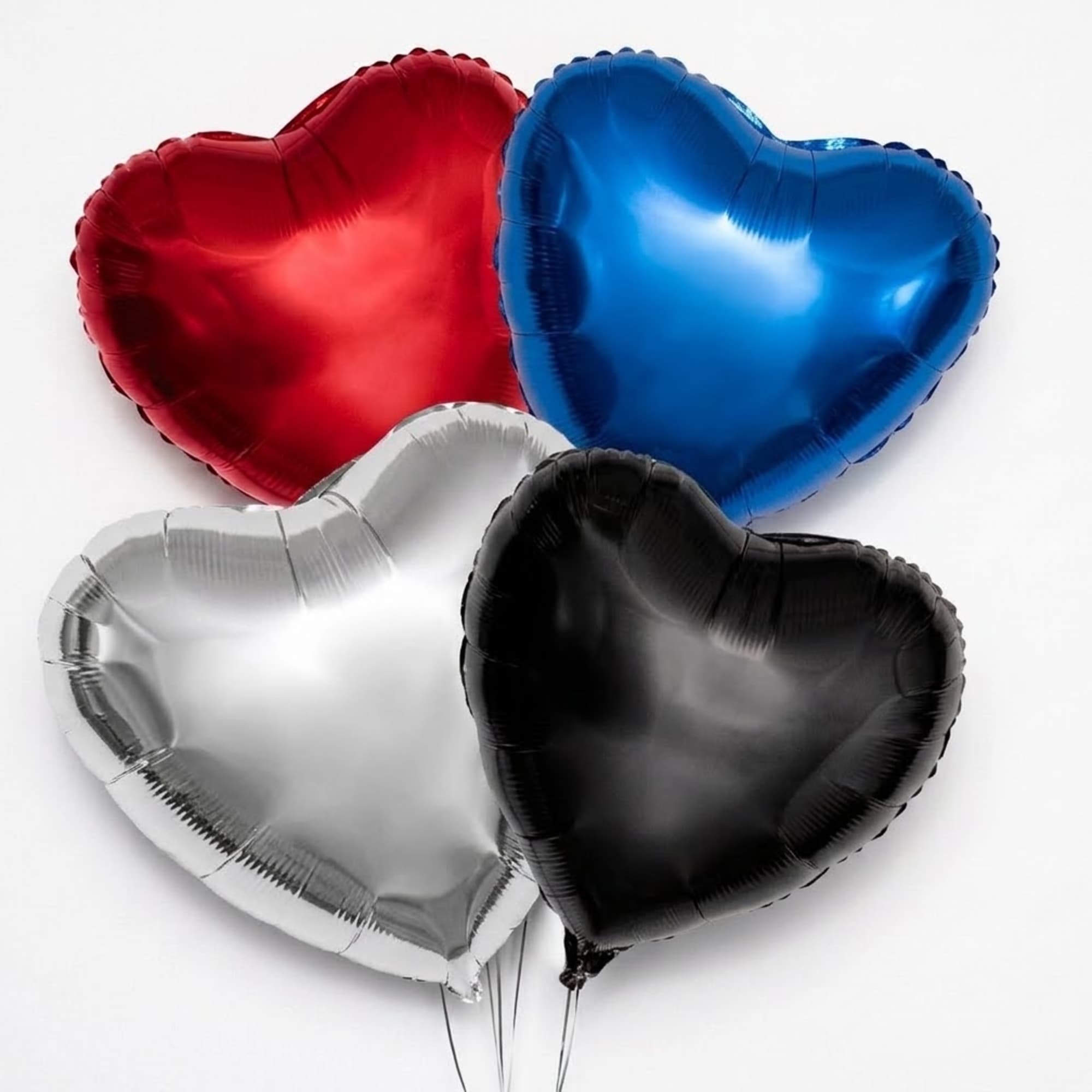 Four heart-shaped balloons in red, blue, silver, and black