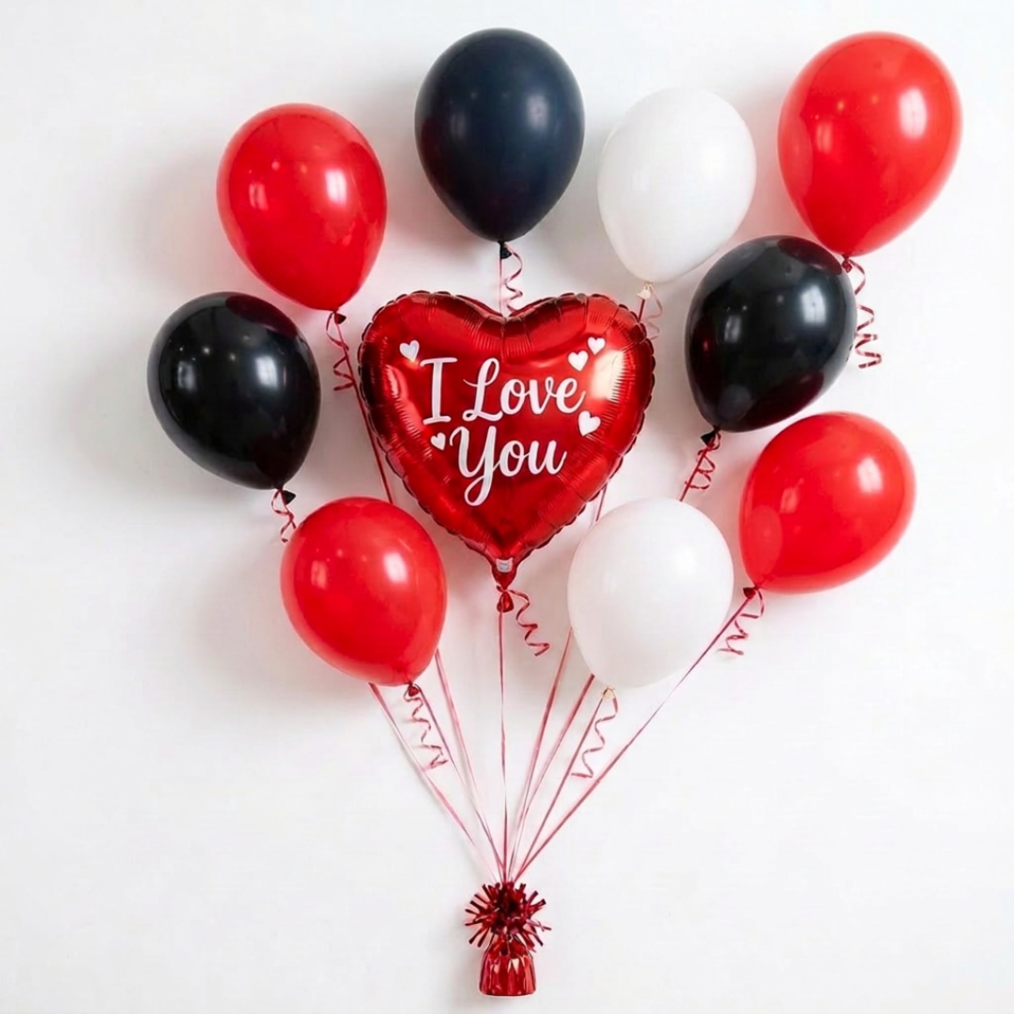 Heart-shaped "I Love You" balloon surrounded by red, black, and white balloons