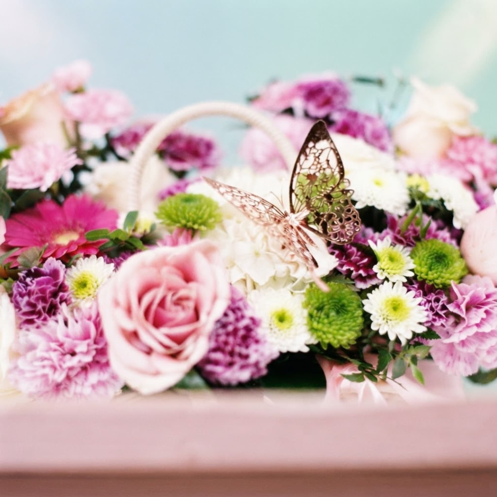 Pink and white flower basket with a butterfly decoration