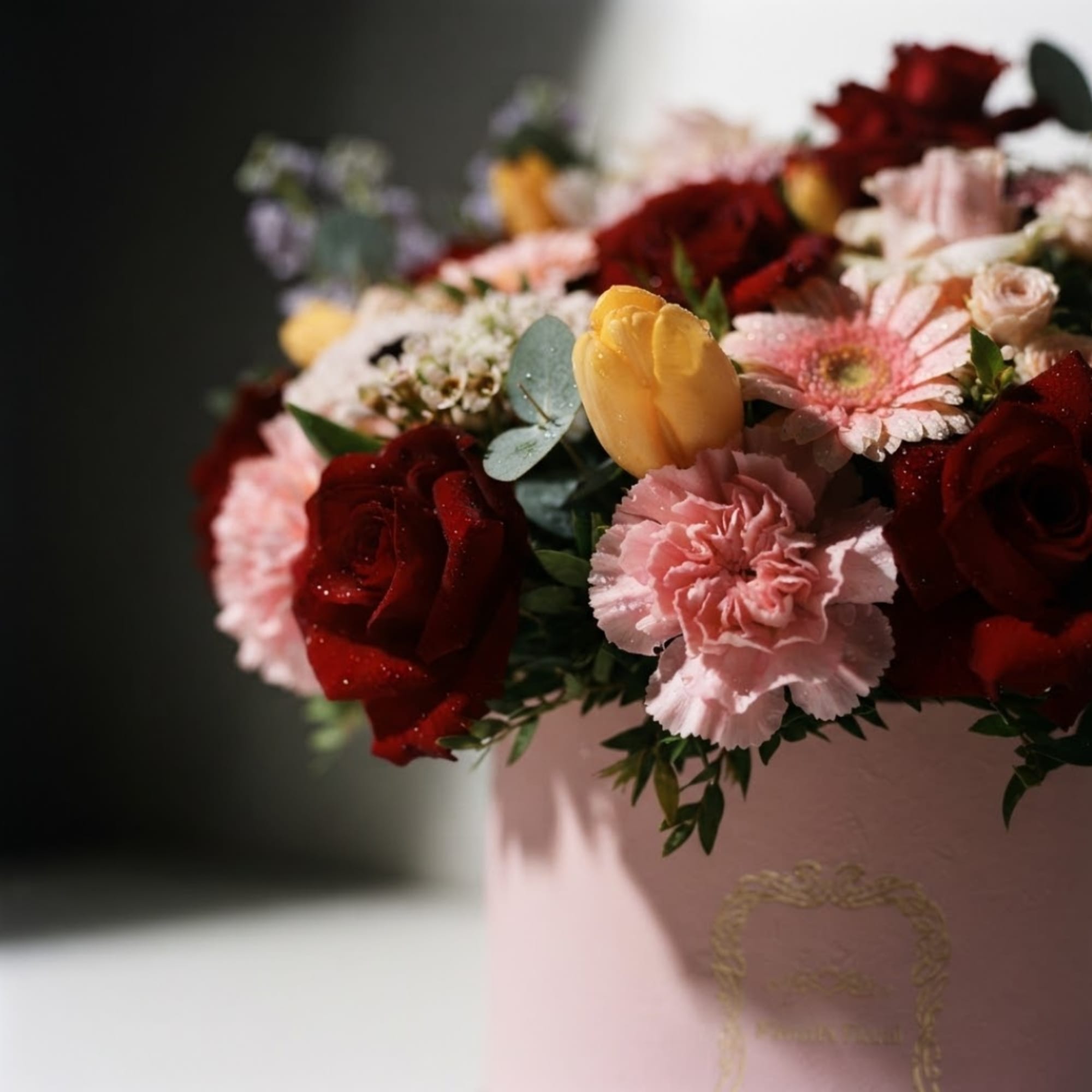 Mixed bouquet of red roses, pink carnations, and yellow tulips in a pink box, photo 4 of 7