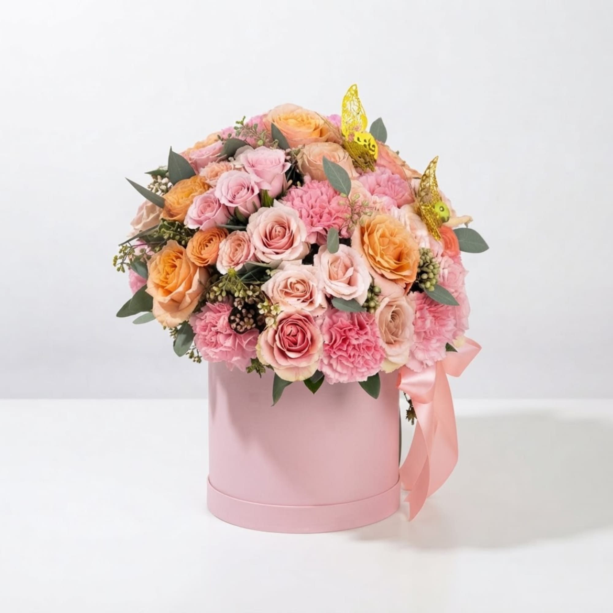 Pink and peach rose bouquet in a pink hat box with ribbon