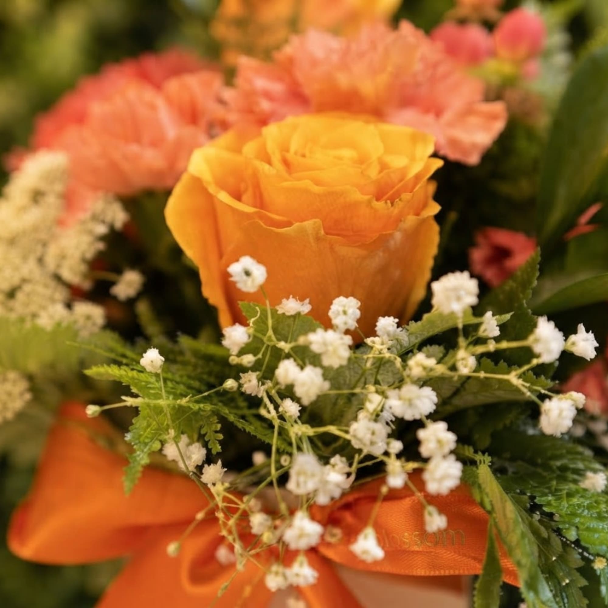 Orange rose bouquet with white baby's breath and pink flowers