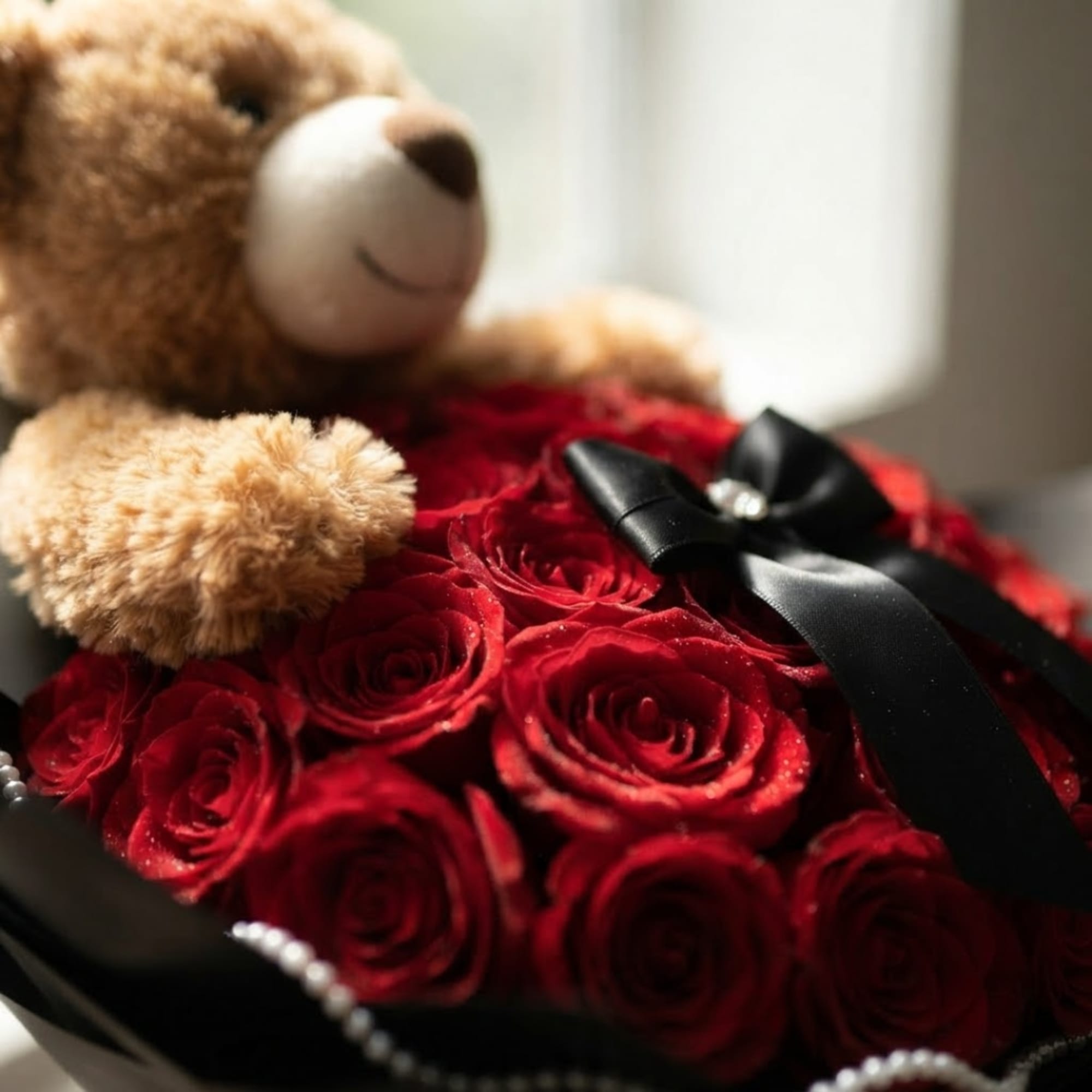 Red rose bouquet with a teddy bear and black ribbon