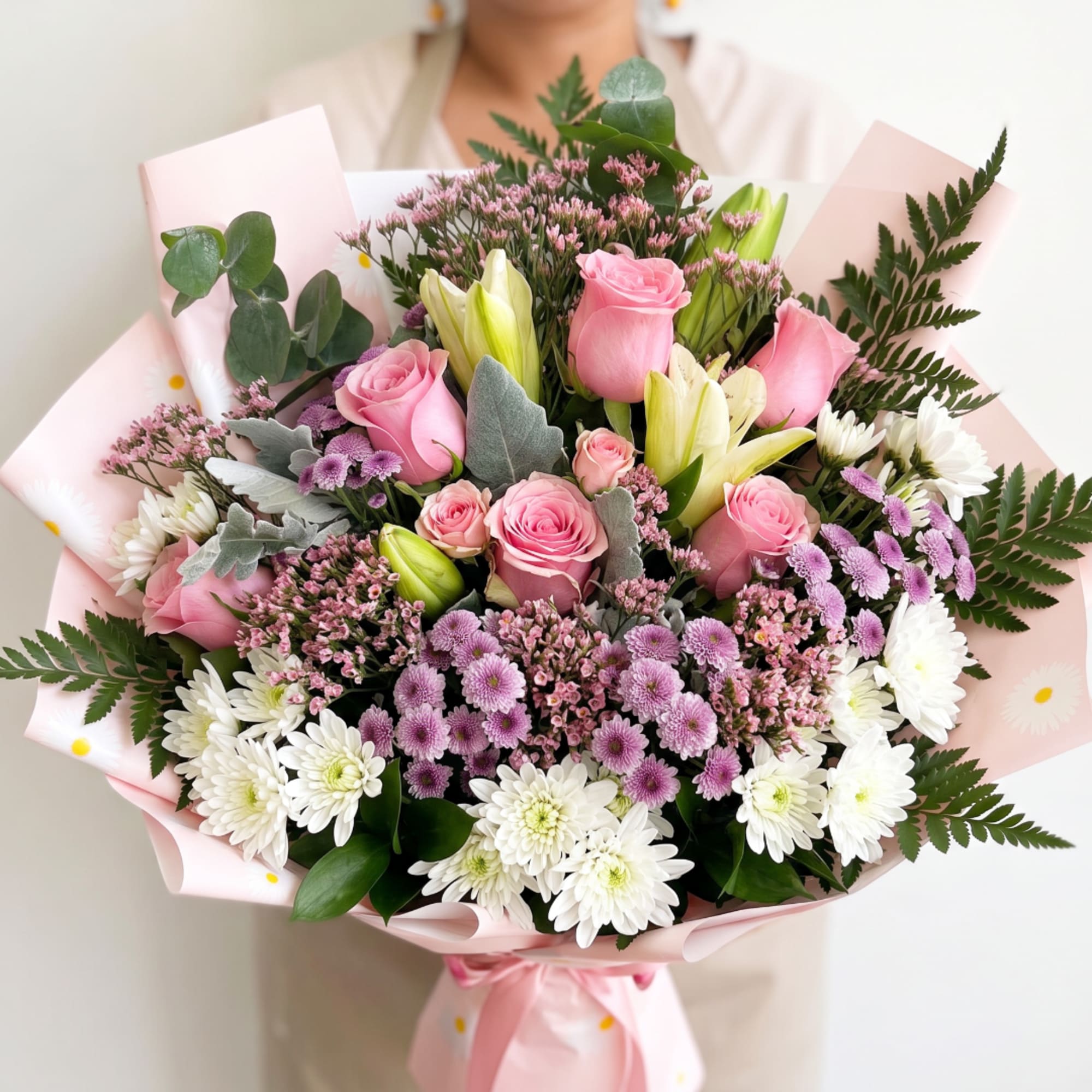 Pink rose and white chrysanthemum bouquet wrapped in pale pink paper