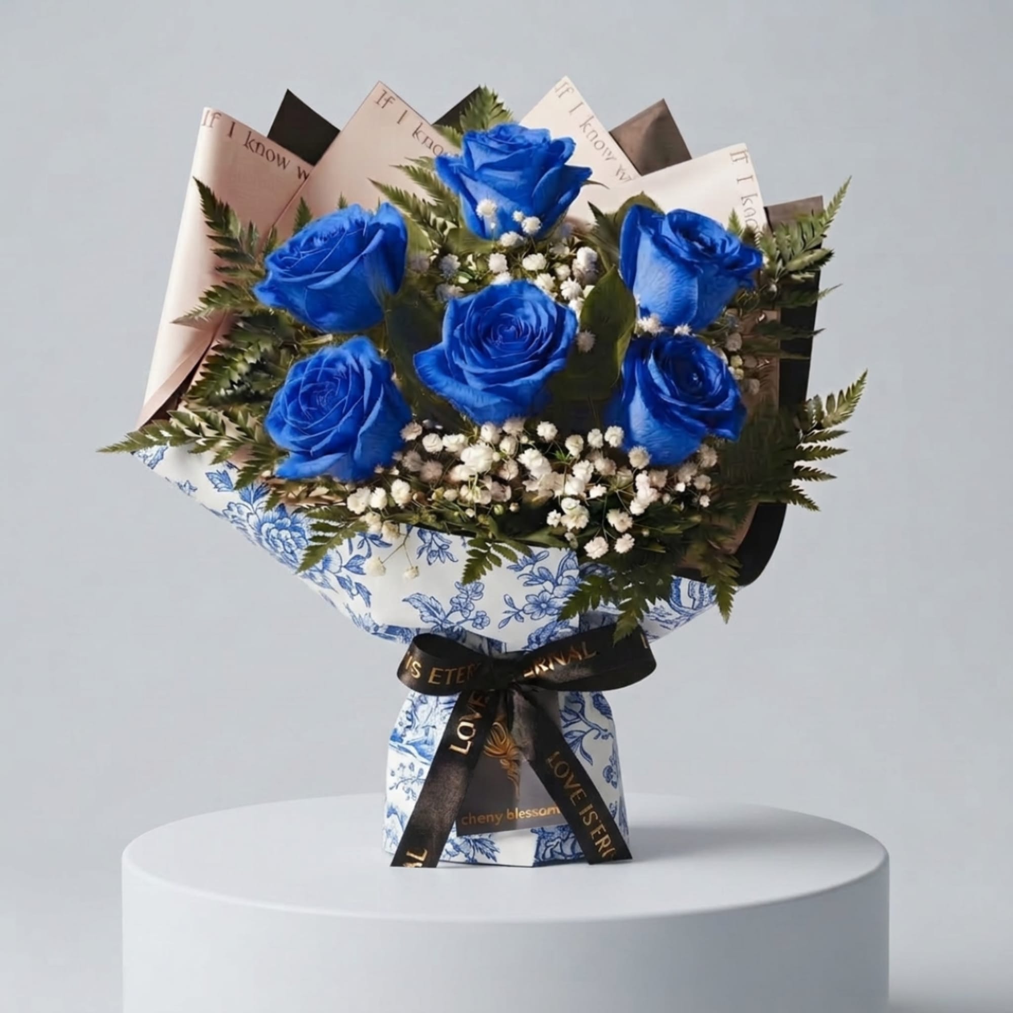 Bouquet of blue roses with white filler flowers and patterned wrapping