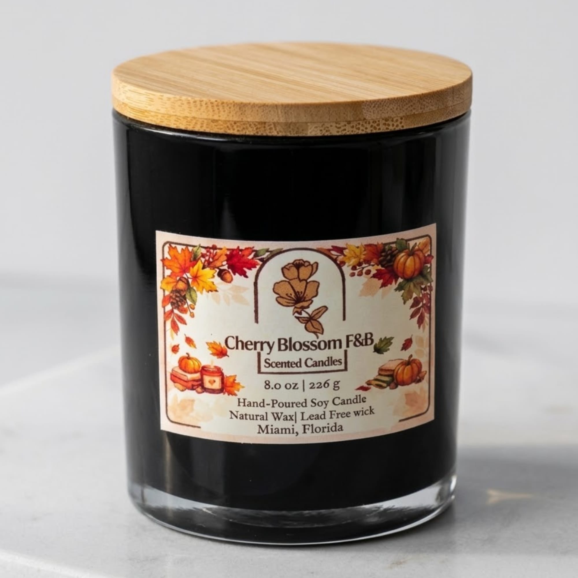 Black scented candle in a glass jar with a wooden lid and fall label