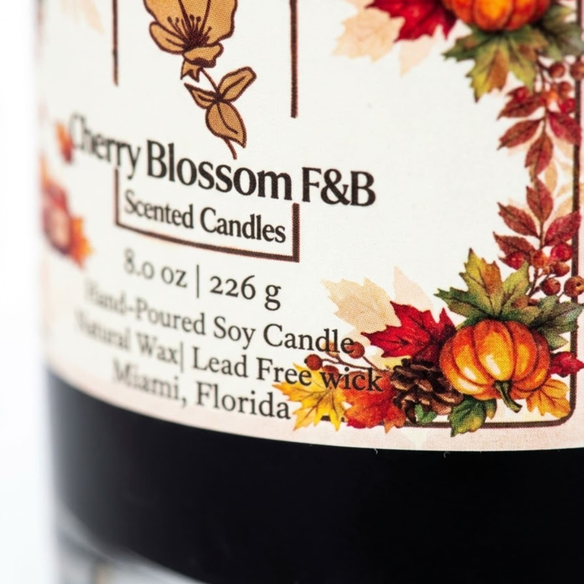 Scented candle jar with an autumn leaf and pumpkin label