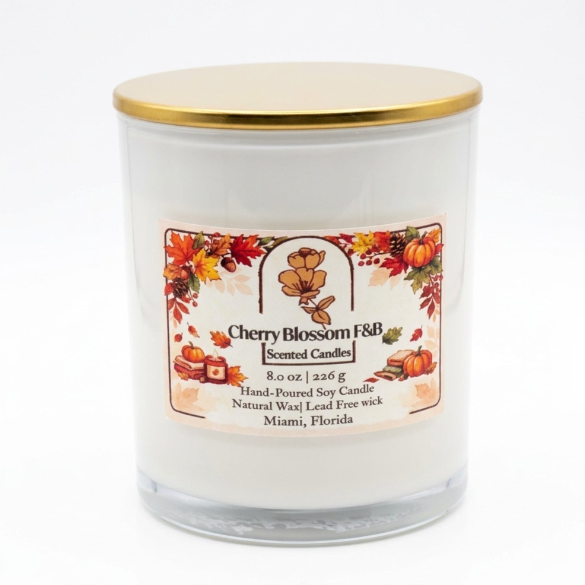 White scented candle in a glass jar with a gold lid