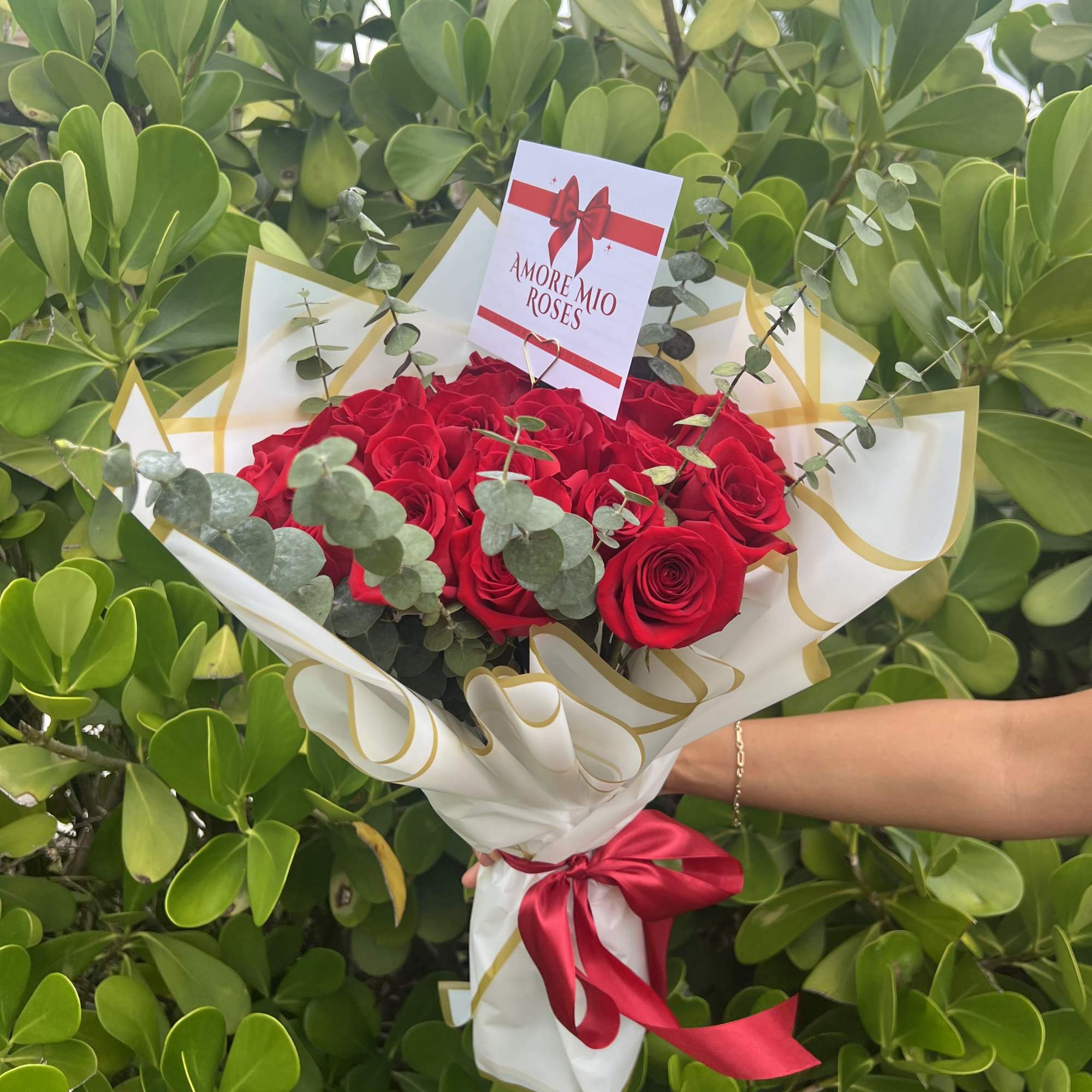 Bouquet of red roses wrapped in white paper with a red ribbon, photo 2 of 4