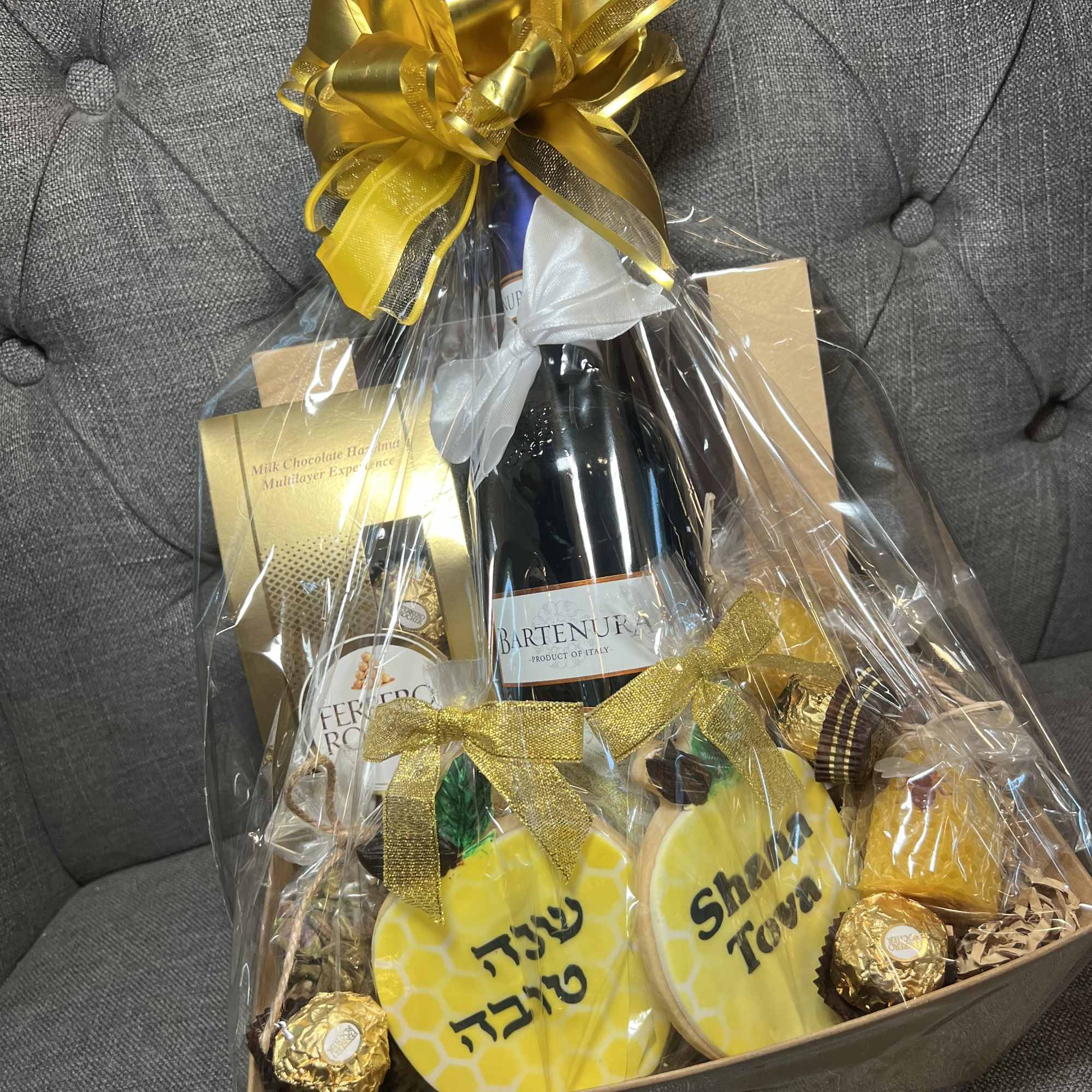 Gift basket with wine, chocolates, and ribbon in clear wrap