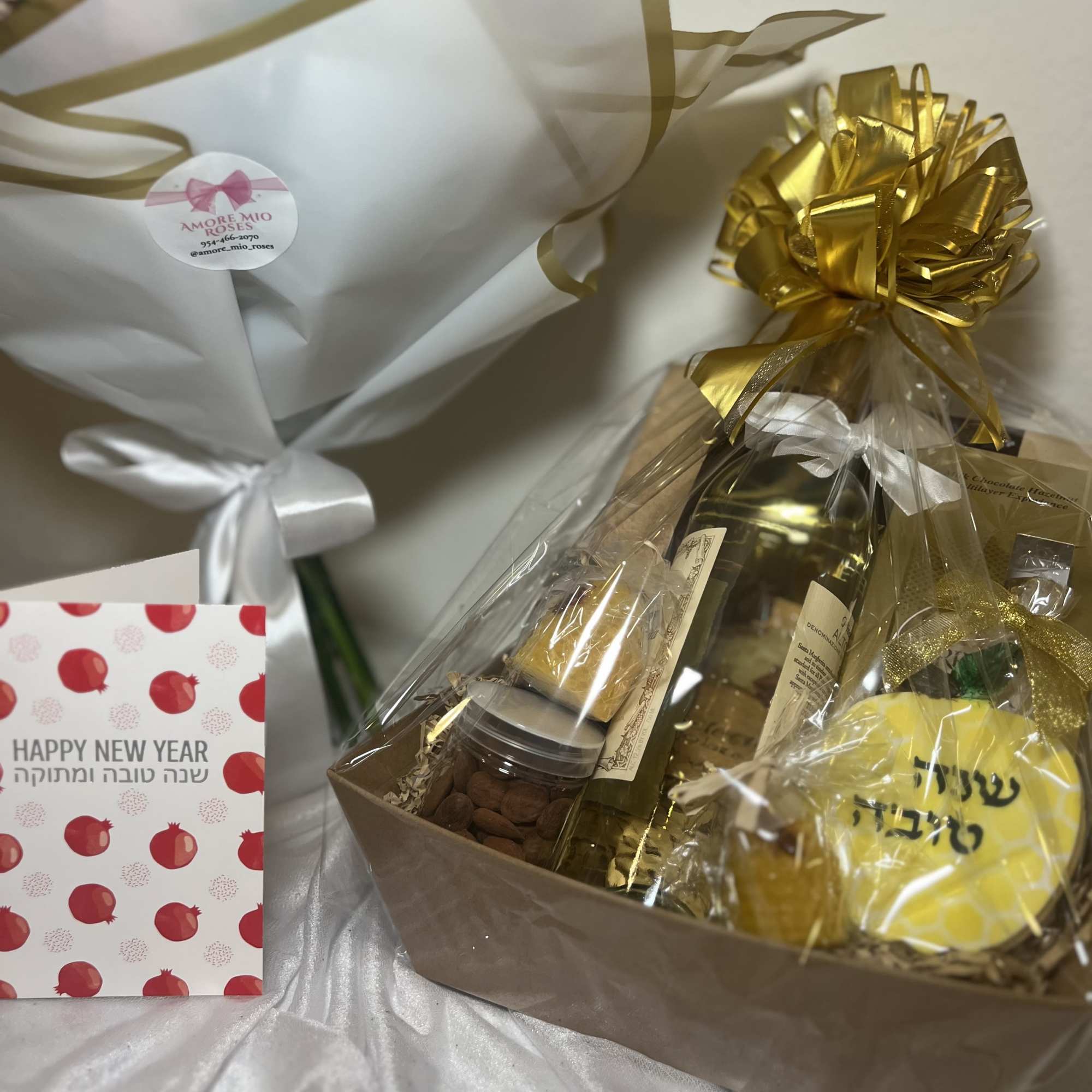Gift basket with wine, sweets, and a bouquet of yellow flowers