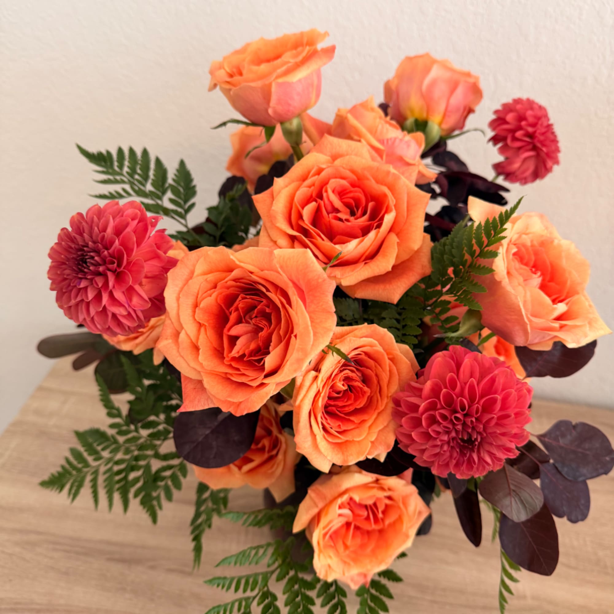 Orange roses and pink dahlias in a compact bouquet