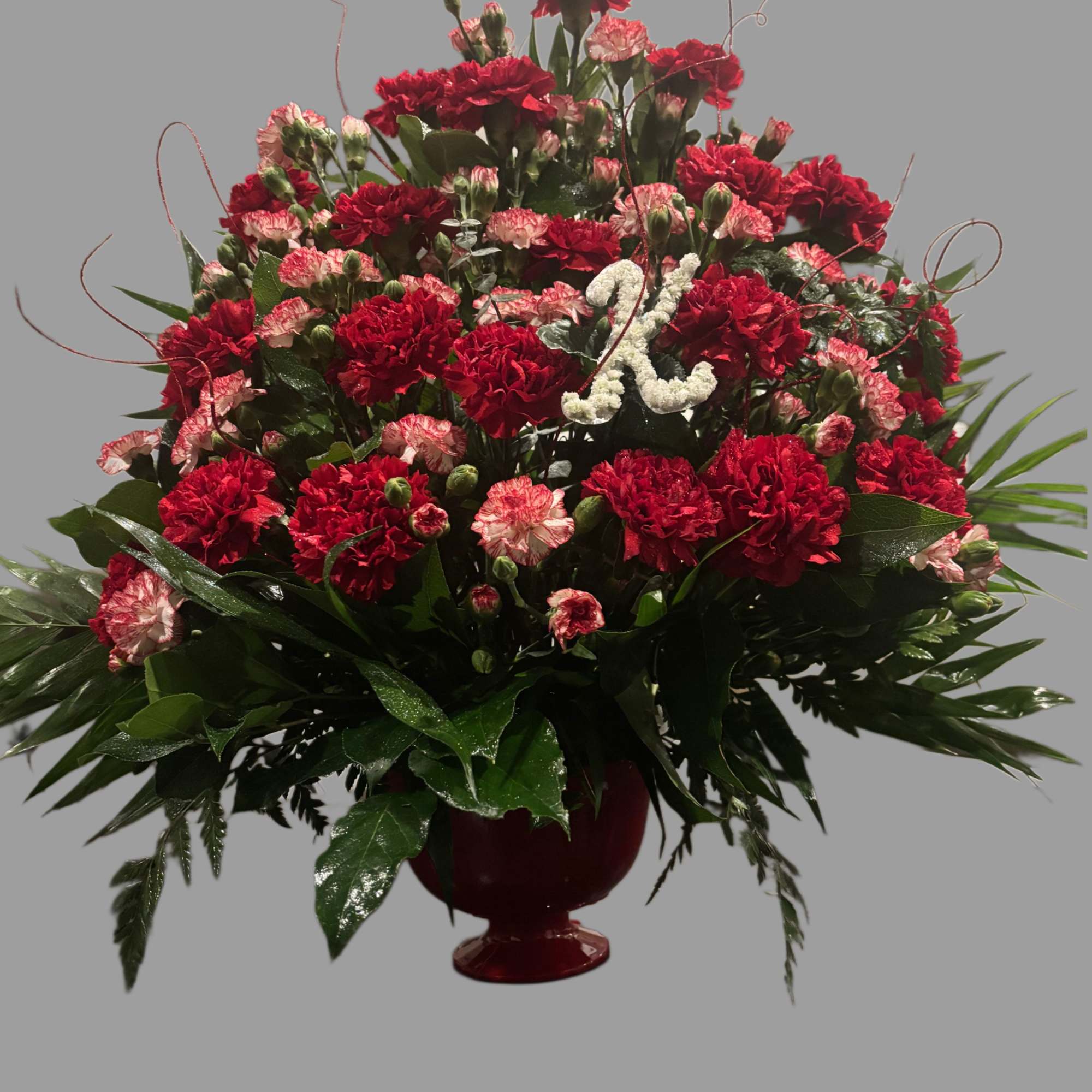 An assortment of carnations with initial made out of baby&rsquo;s breath. 