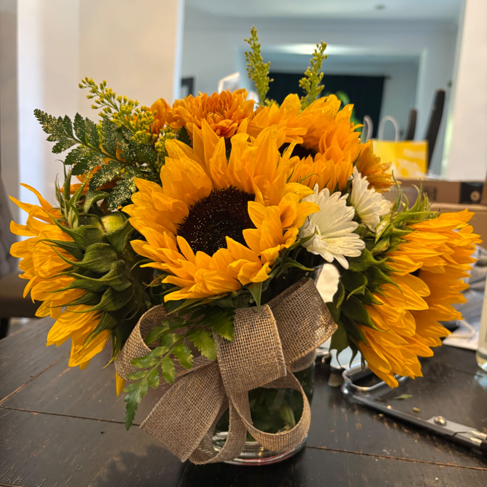 Sunflower bouquet in a glass vase with a burlap bow